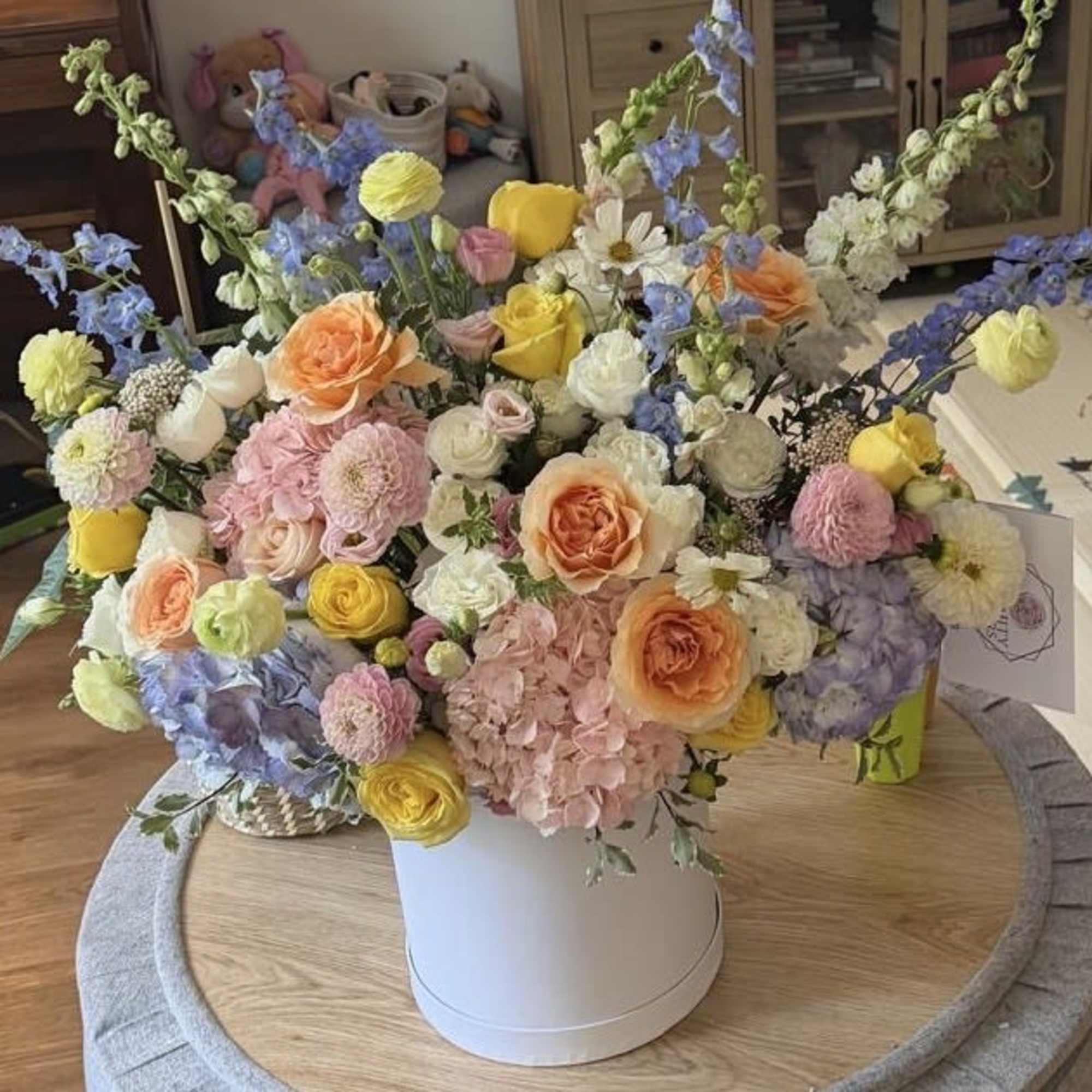 A refined arrangement of premium roses and seasonal blooms in soft pastel