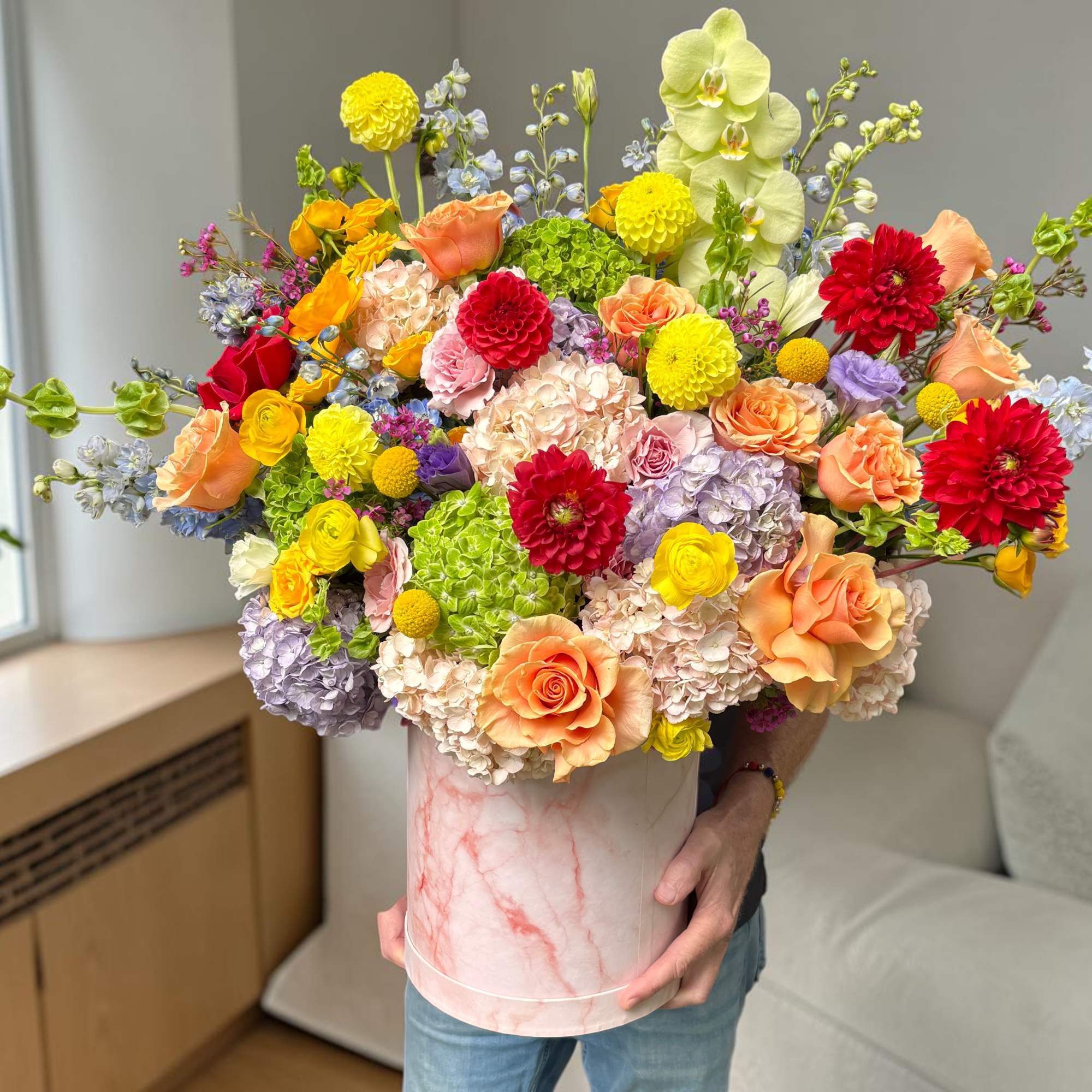 Large mixed bouquet in a pink marble-look box with orchids and roses