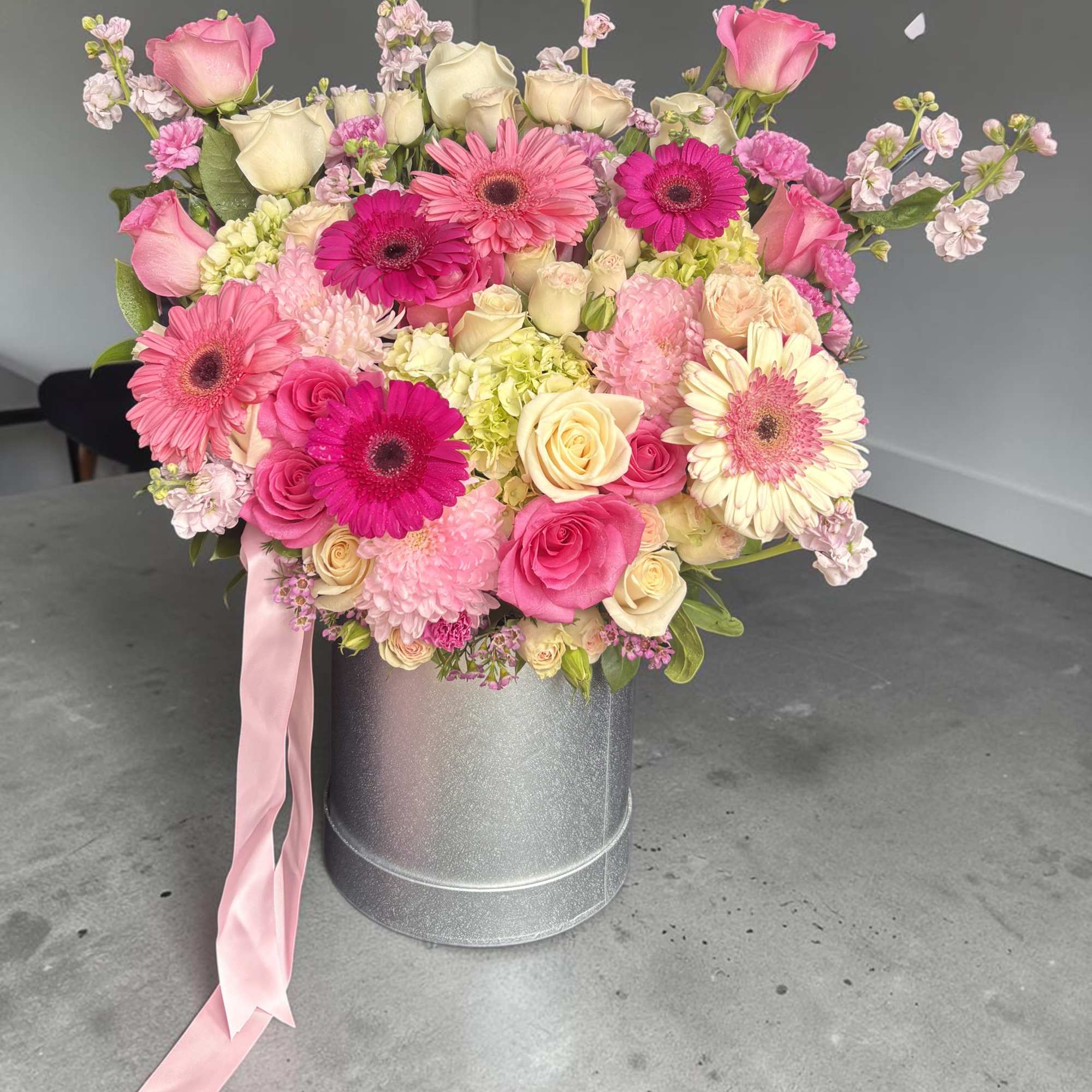 Pink and cream mixed bouquet in a silver hatbox with a pink ribbon