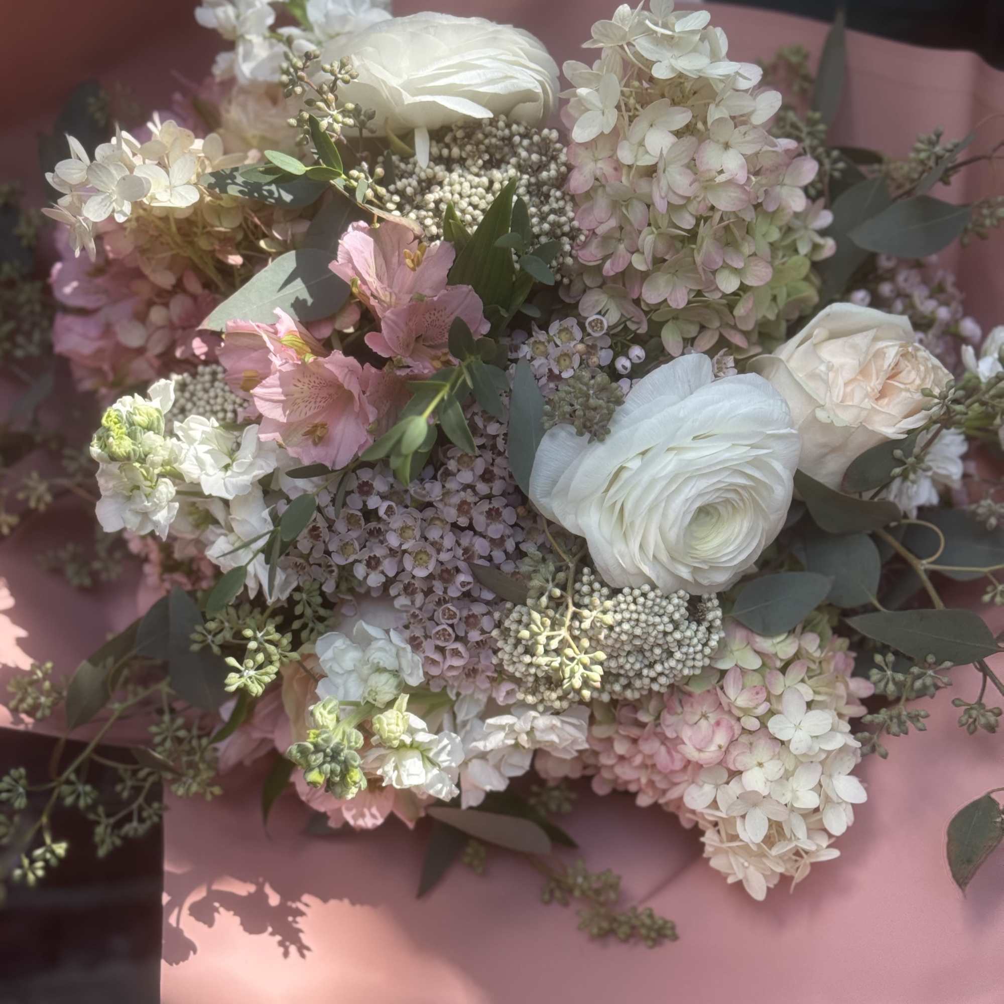 Pastel bouquet with white and pink flowers wrapped in pink paper