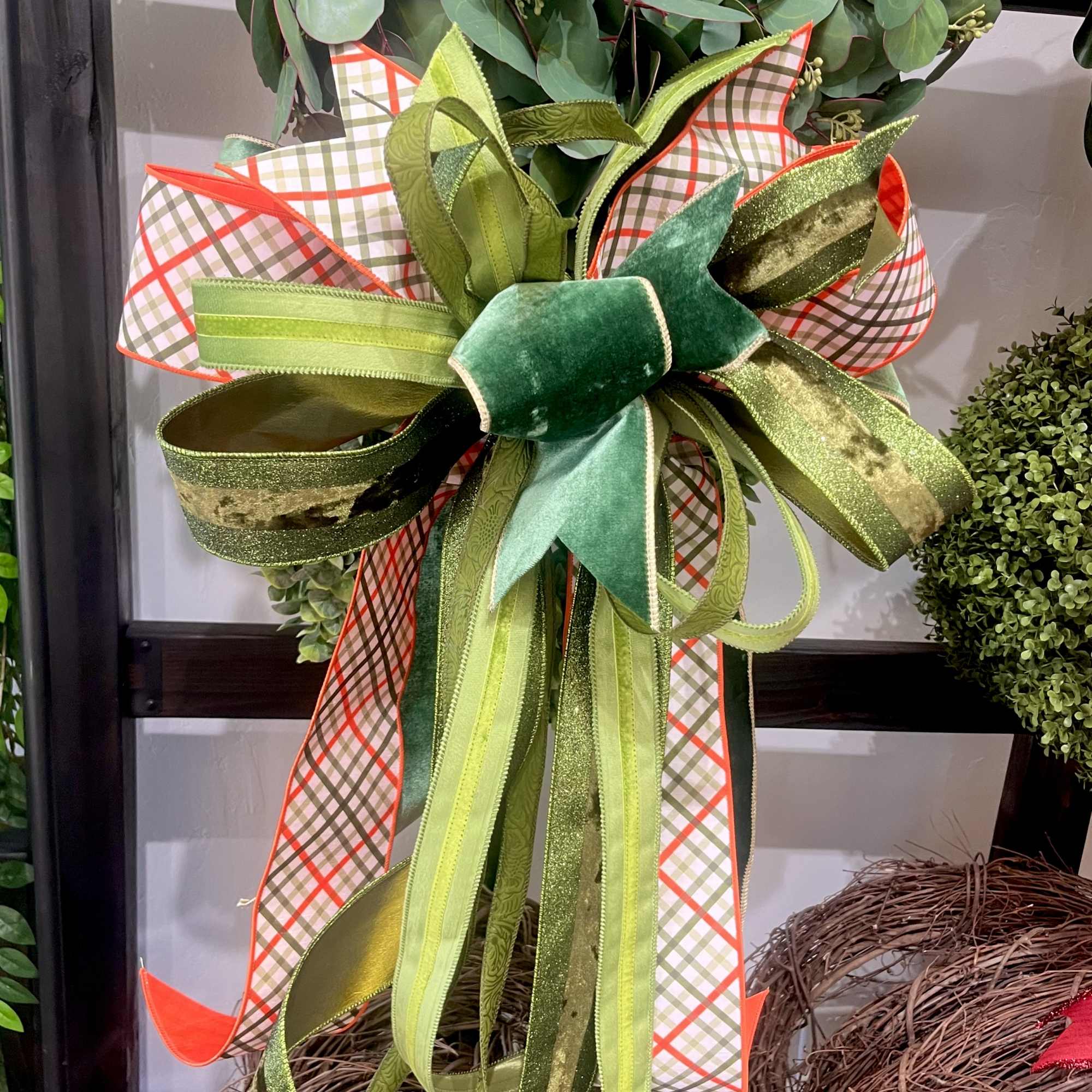 Decorative green ribbon bow tied around a wreath with eucalyptus foliage