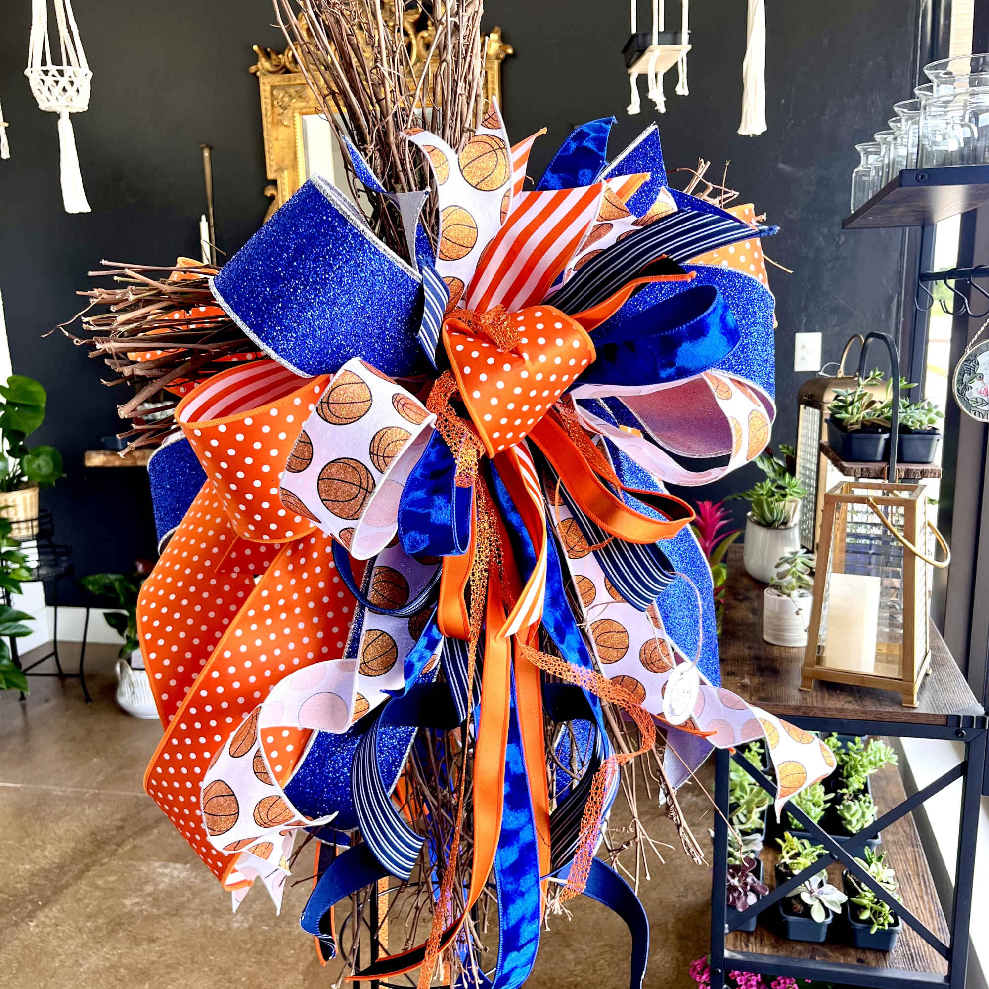 Decorative wreath with blue and orange ribbons on a twig base
