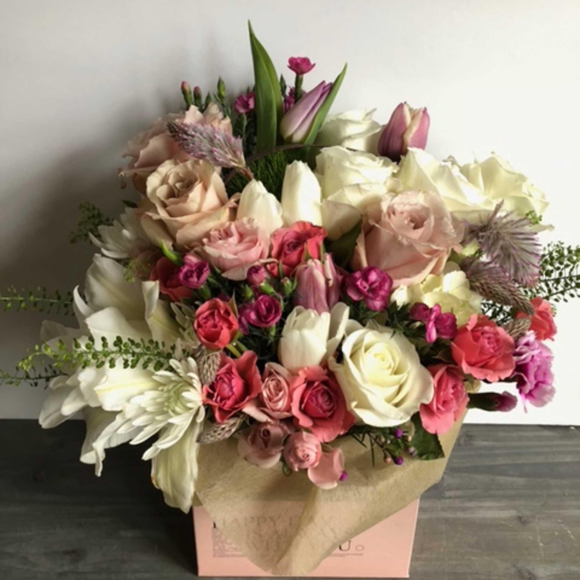 Mixed bouquet of pink and white roses with tulips in a box