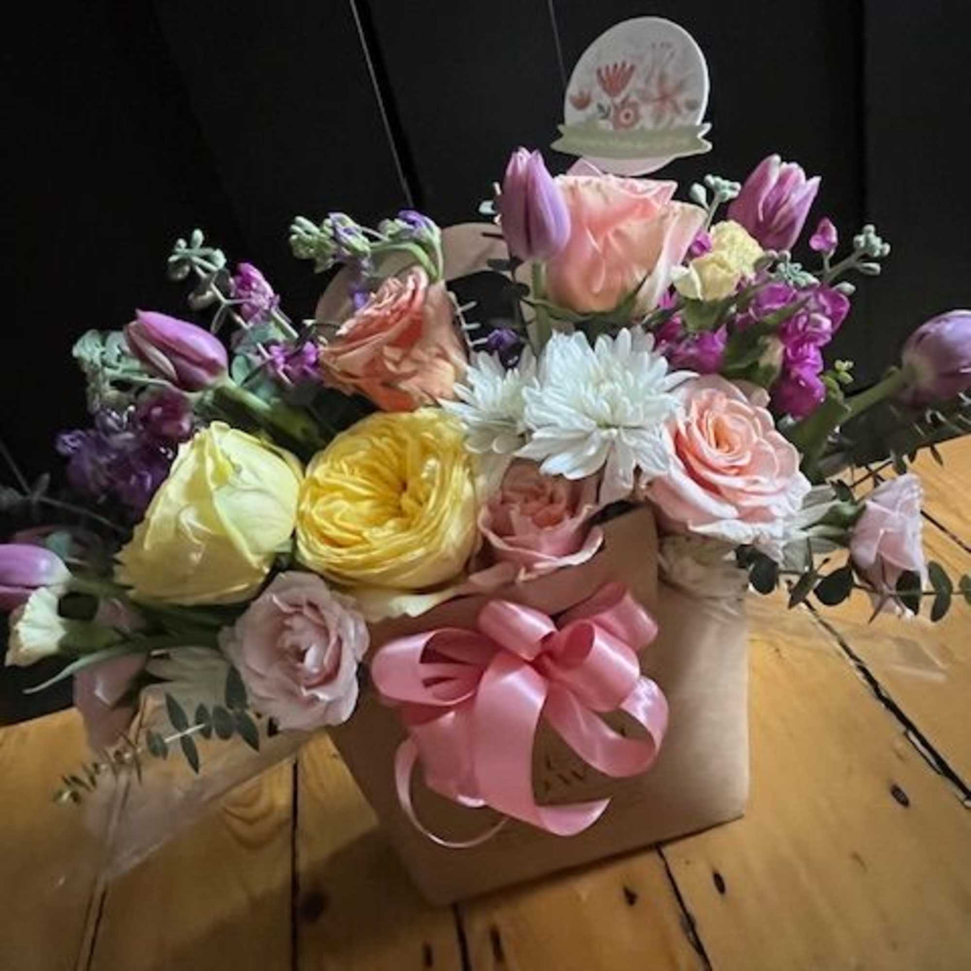 Mixed pastel flower arrangement in a kraft box with a pink ribbon