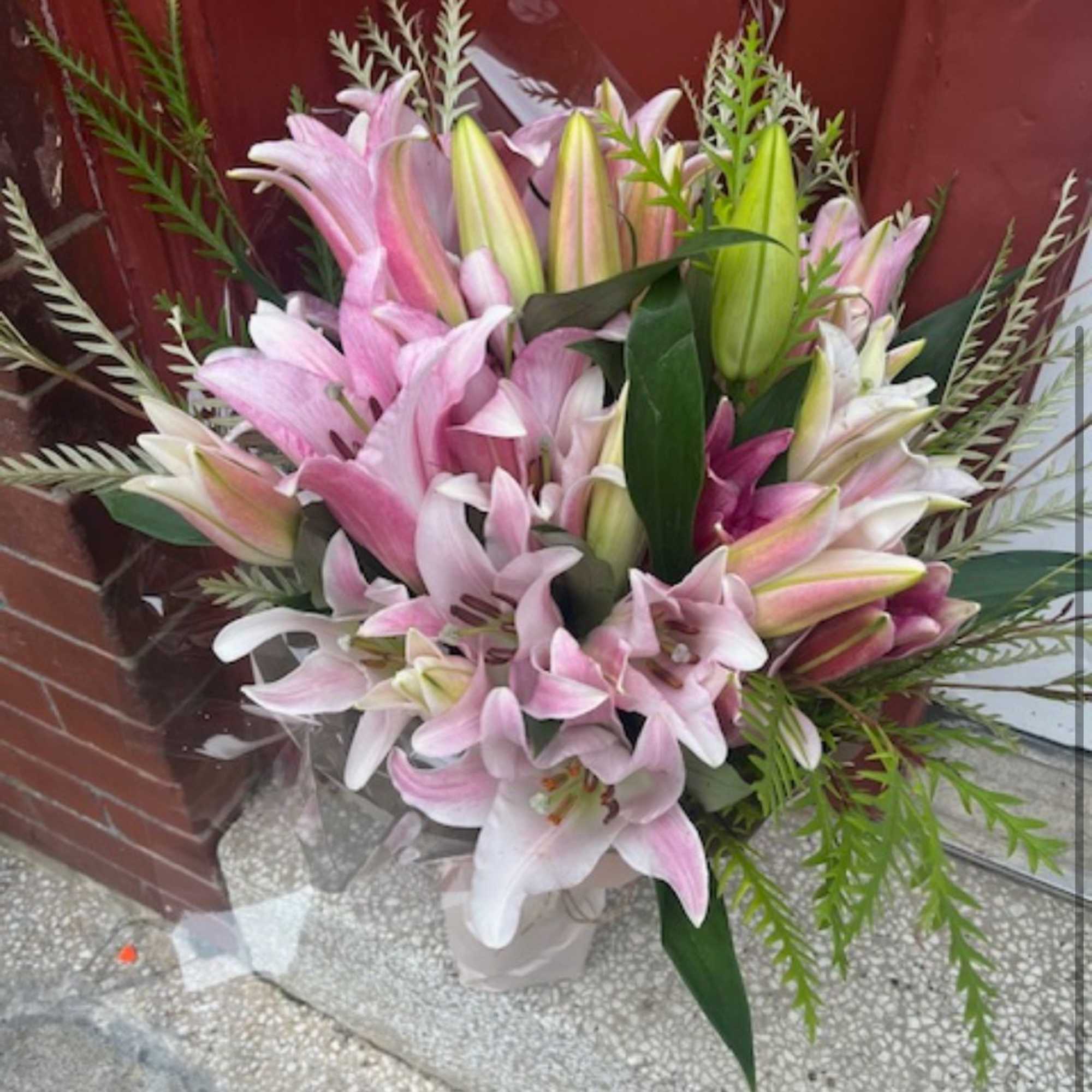 Bouquet of pink and white lilies in a wrapped container