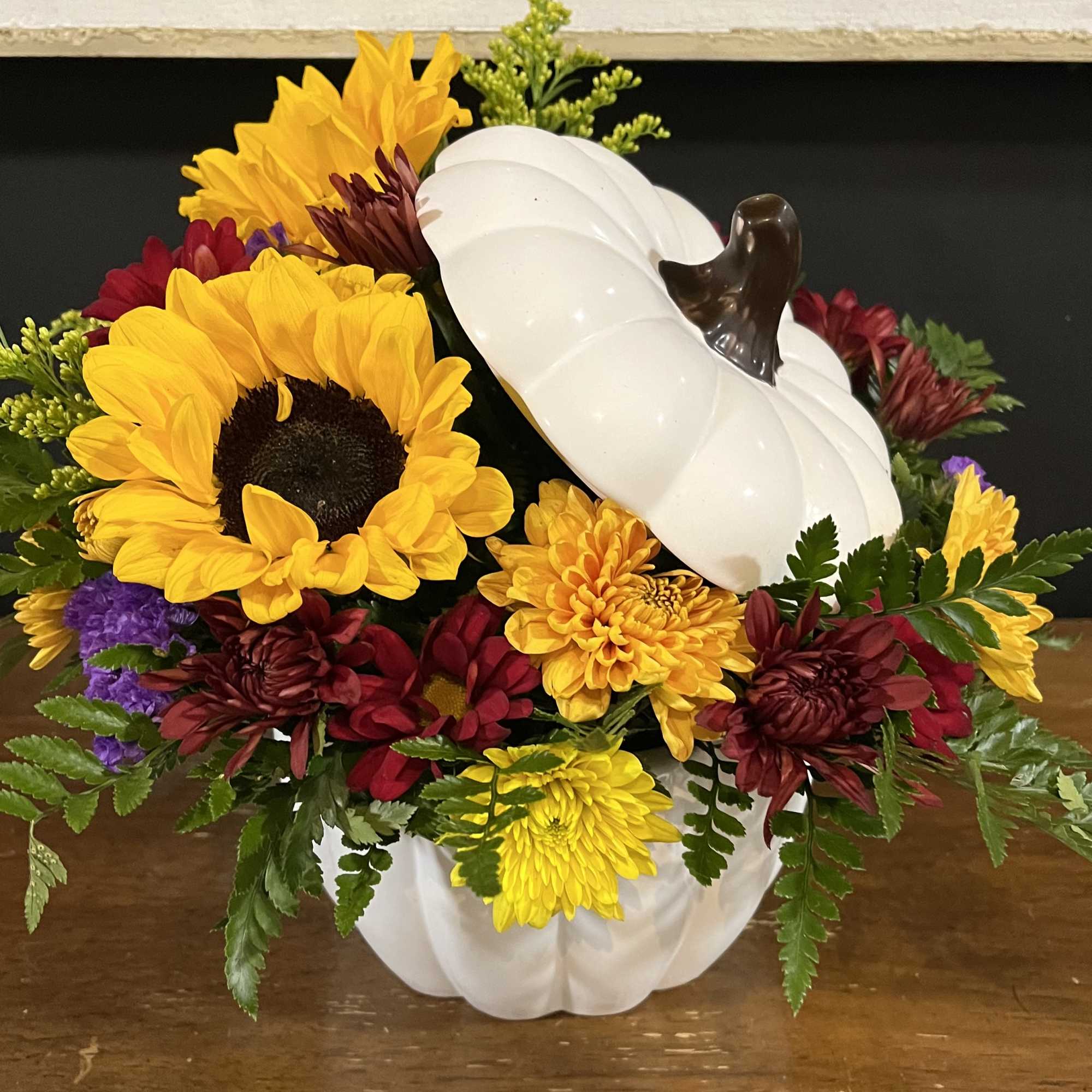 This cheerful autumn arrangement in an orange or white pumpkin is perfect