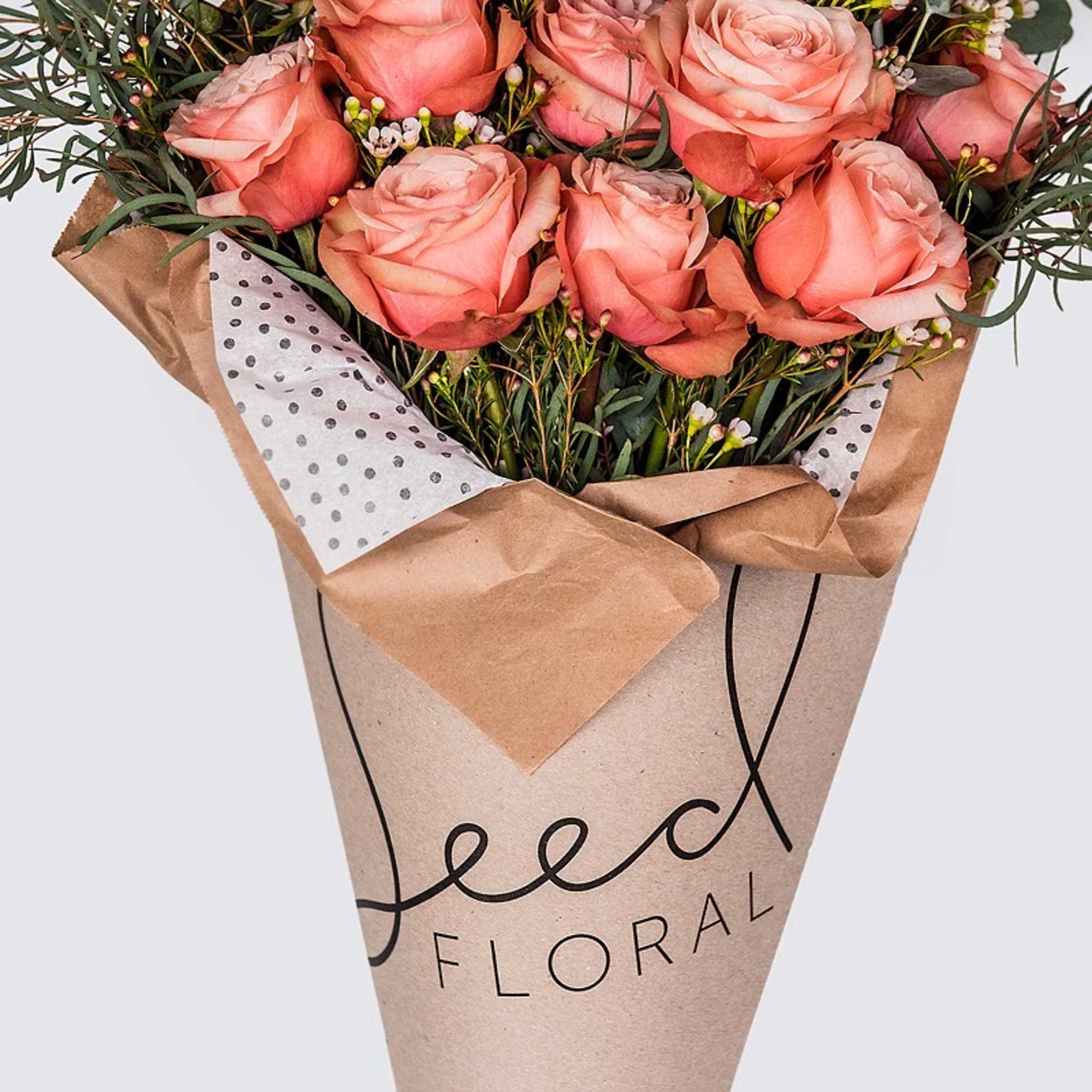 Bouquet of peach-pink roses wrapped in kraft paper