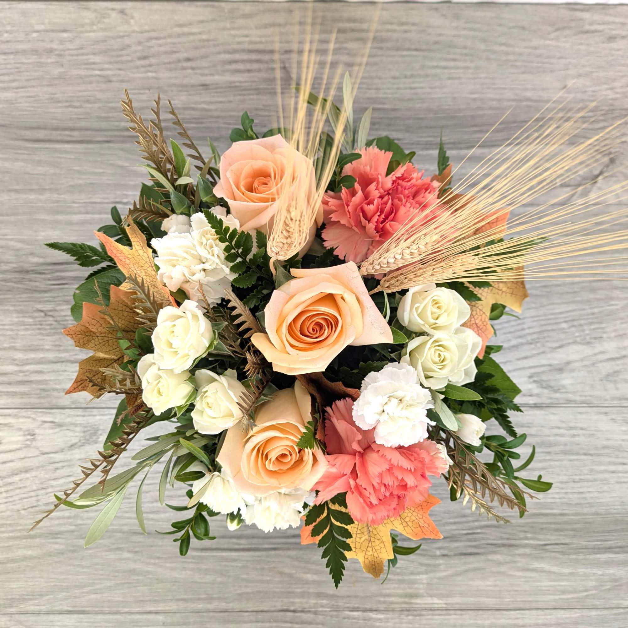Bouquet of peach roses, white carnations, and pink carnations