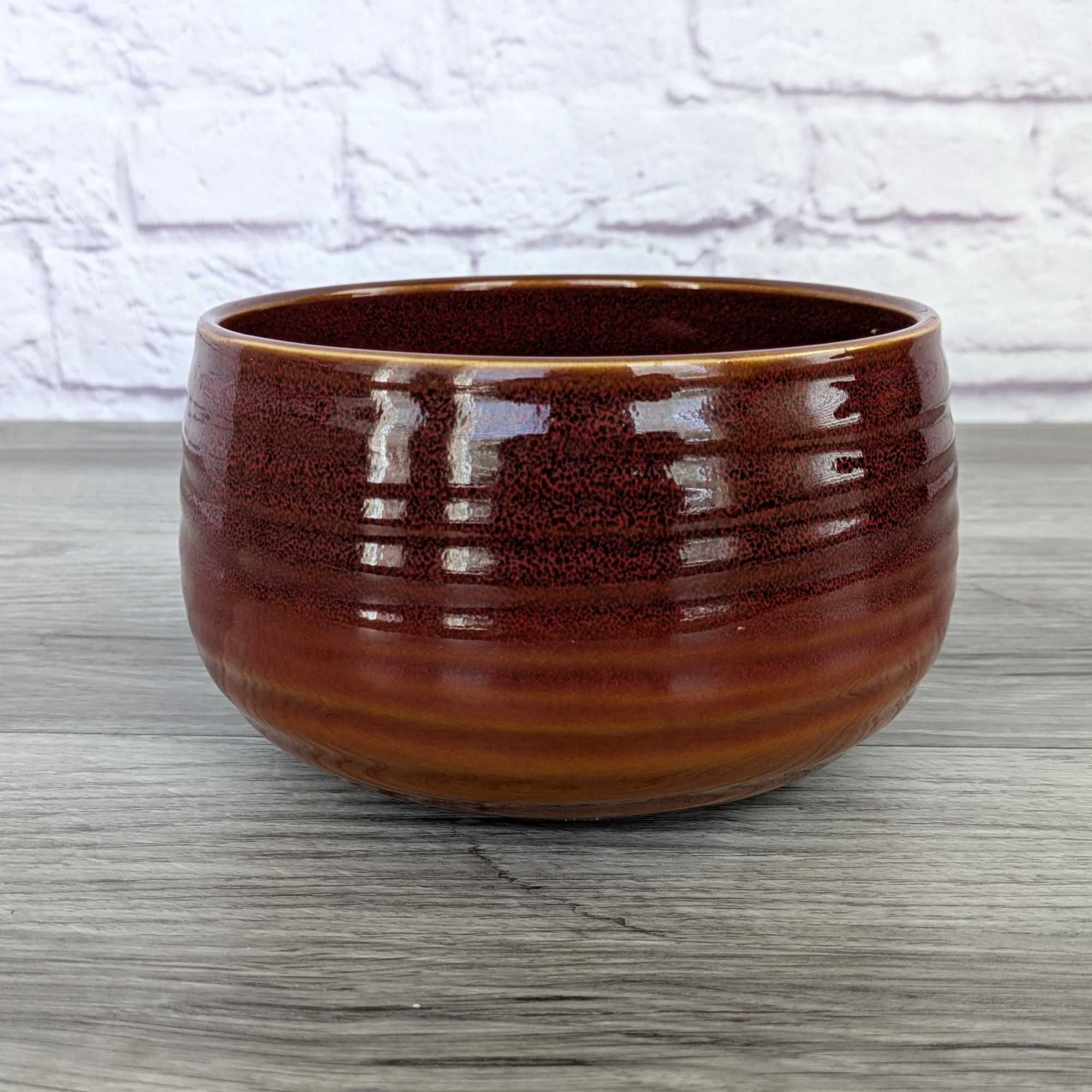 Brown ceramic bowl-shaped planter on a tabletop