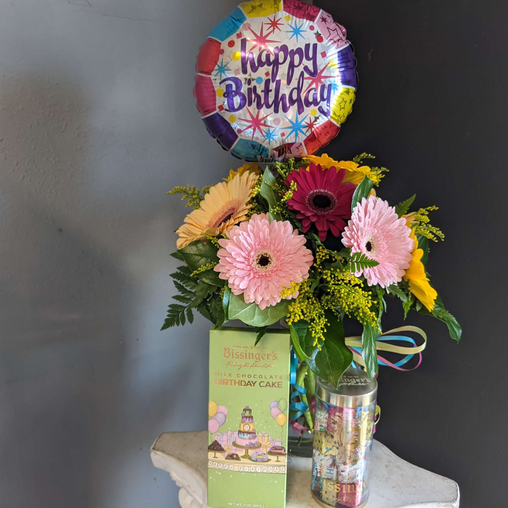 A dozen Gerbera Daisy paired with fun birthday items. 