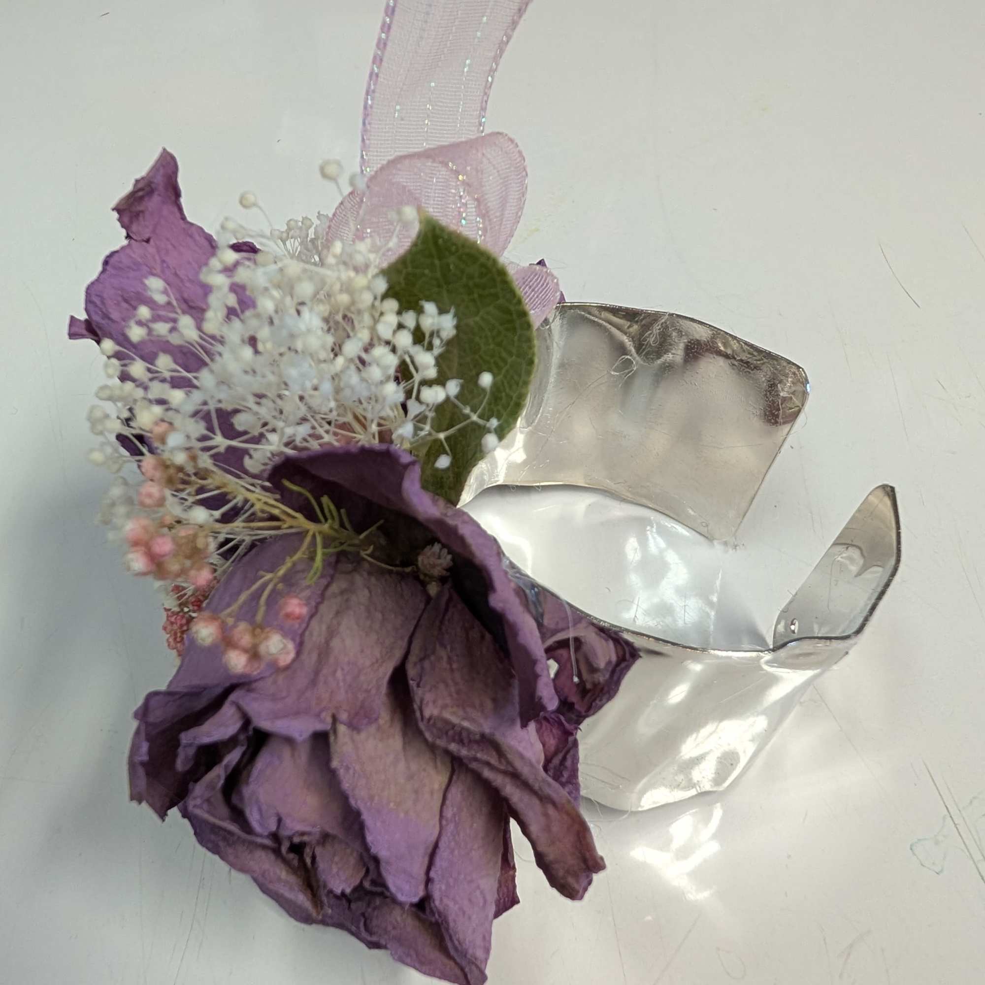 A forever keepsake. This silver bracelet is dressed up with dried roses