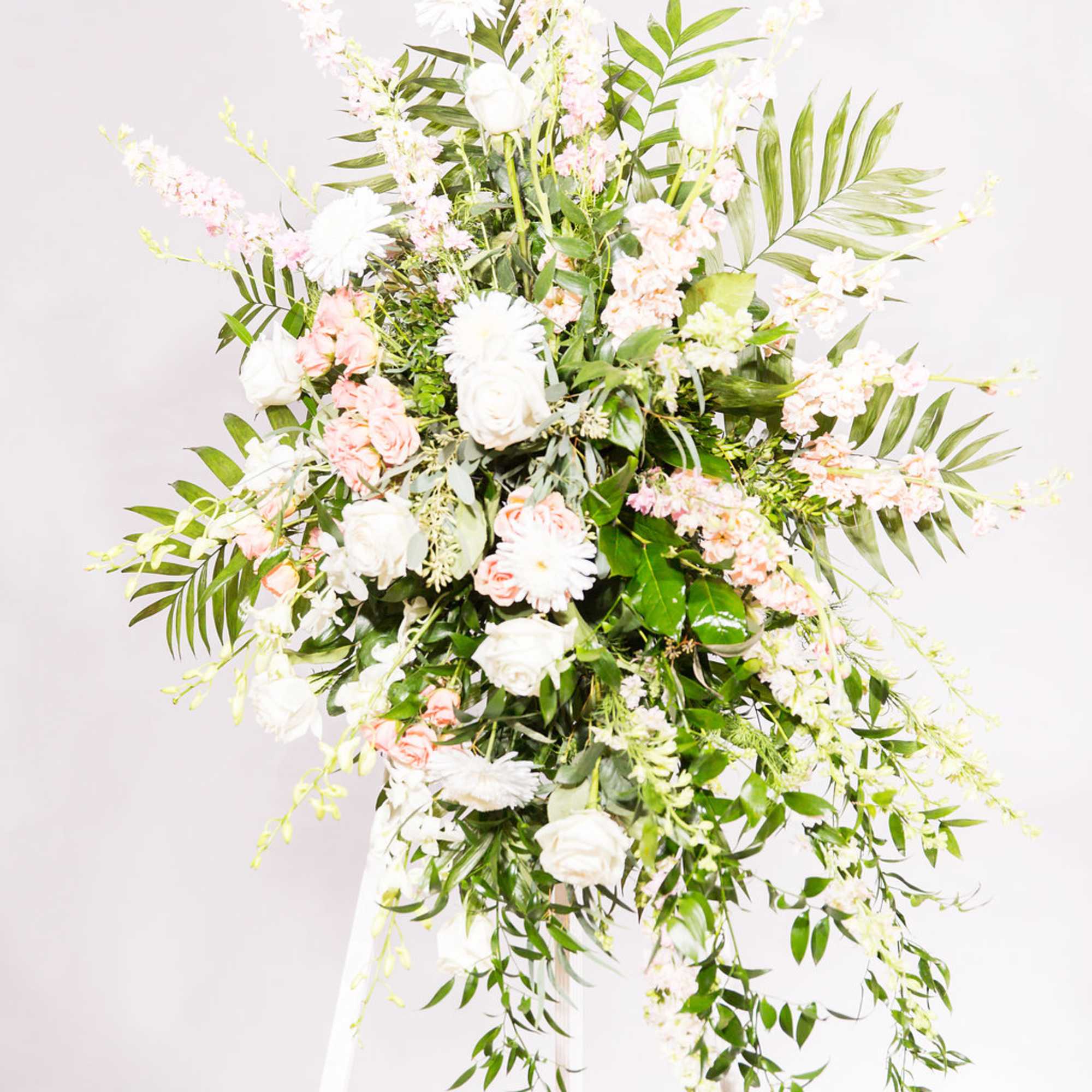 Tall white and blush floral standing arrangement on an easel