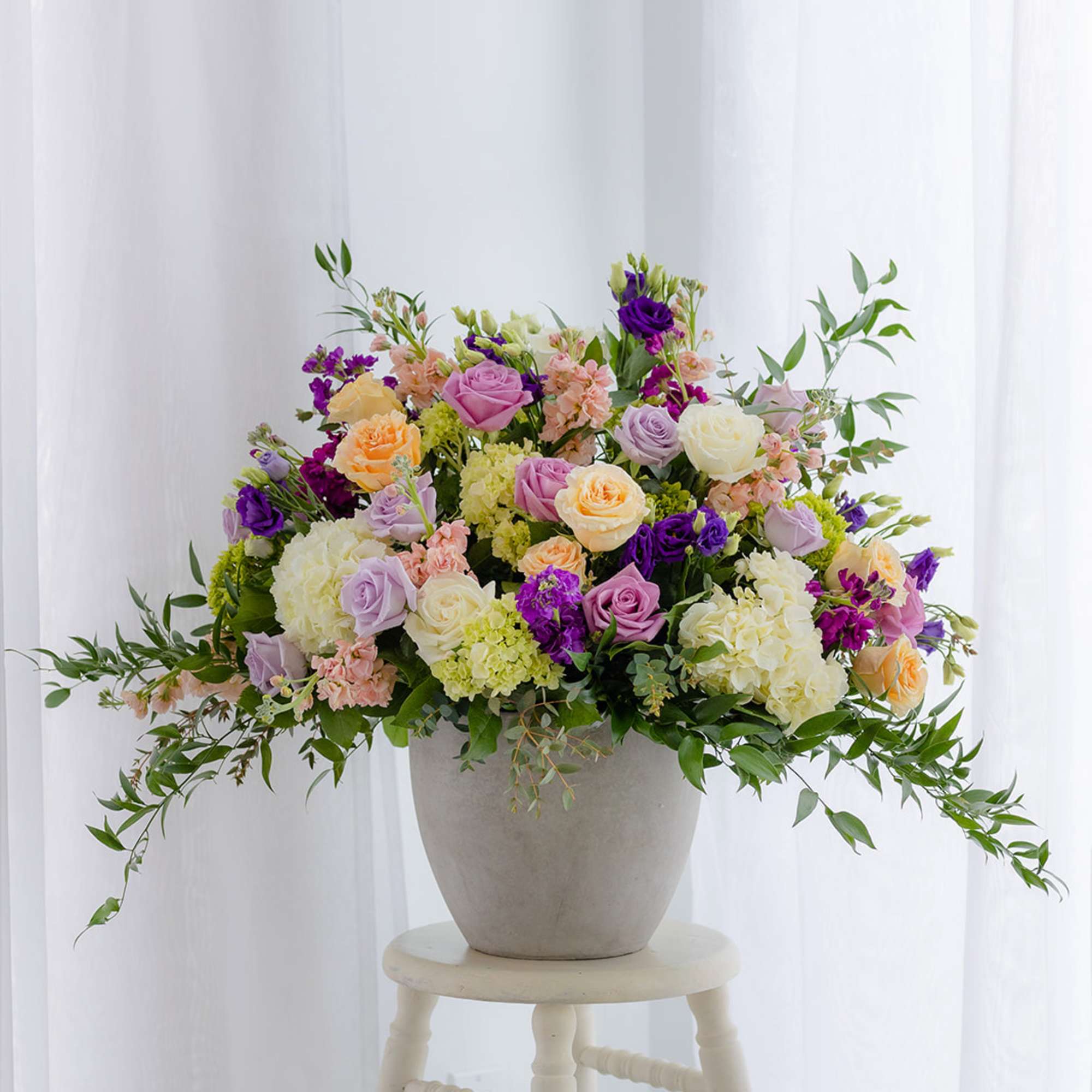Large mixed bouquet in a gray vase with pink, purple, white, and peach flowers