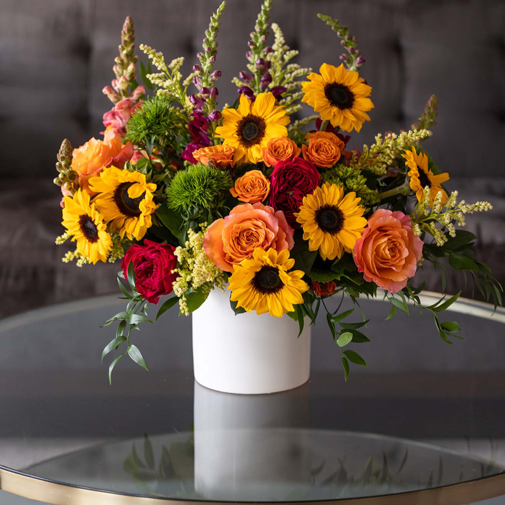 Mixed bouquet of sunflowers and roses in a white vase