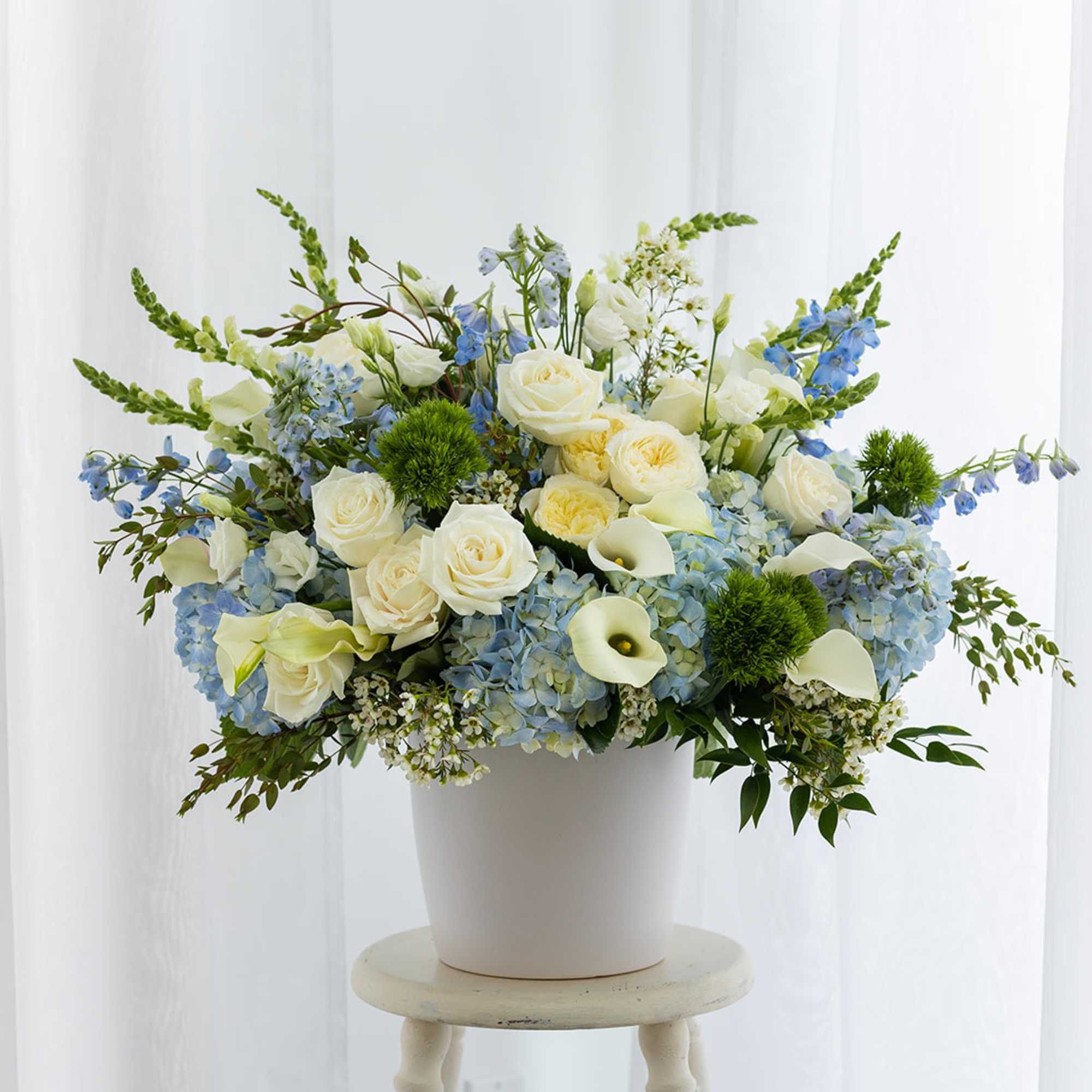 Blue and white floral arrangement in a white pot, photo 2 of 3
