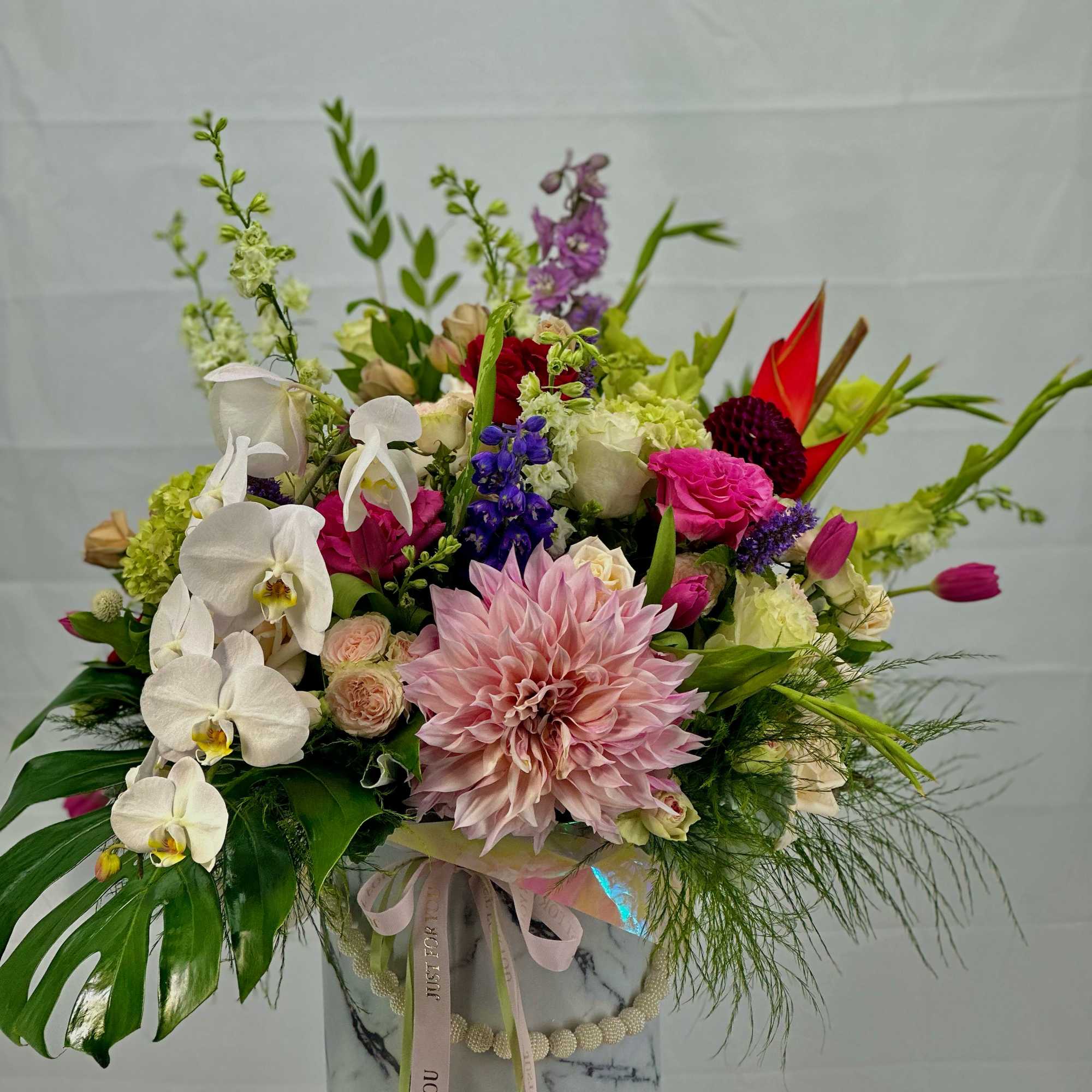 Mixed bouquet in a marble-patterned box with pink and white blooms