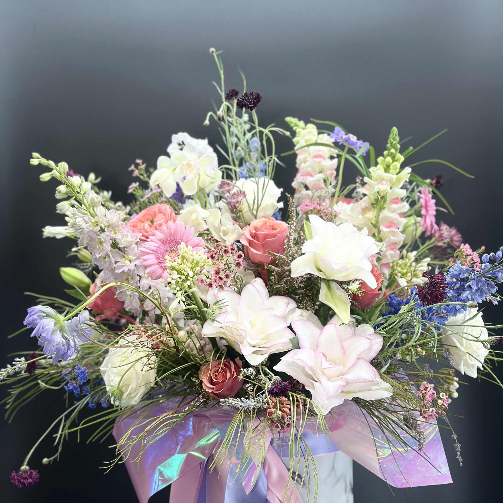 Mixed pastel bouquet in a marble vase with pink and white blooms