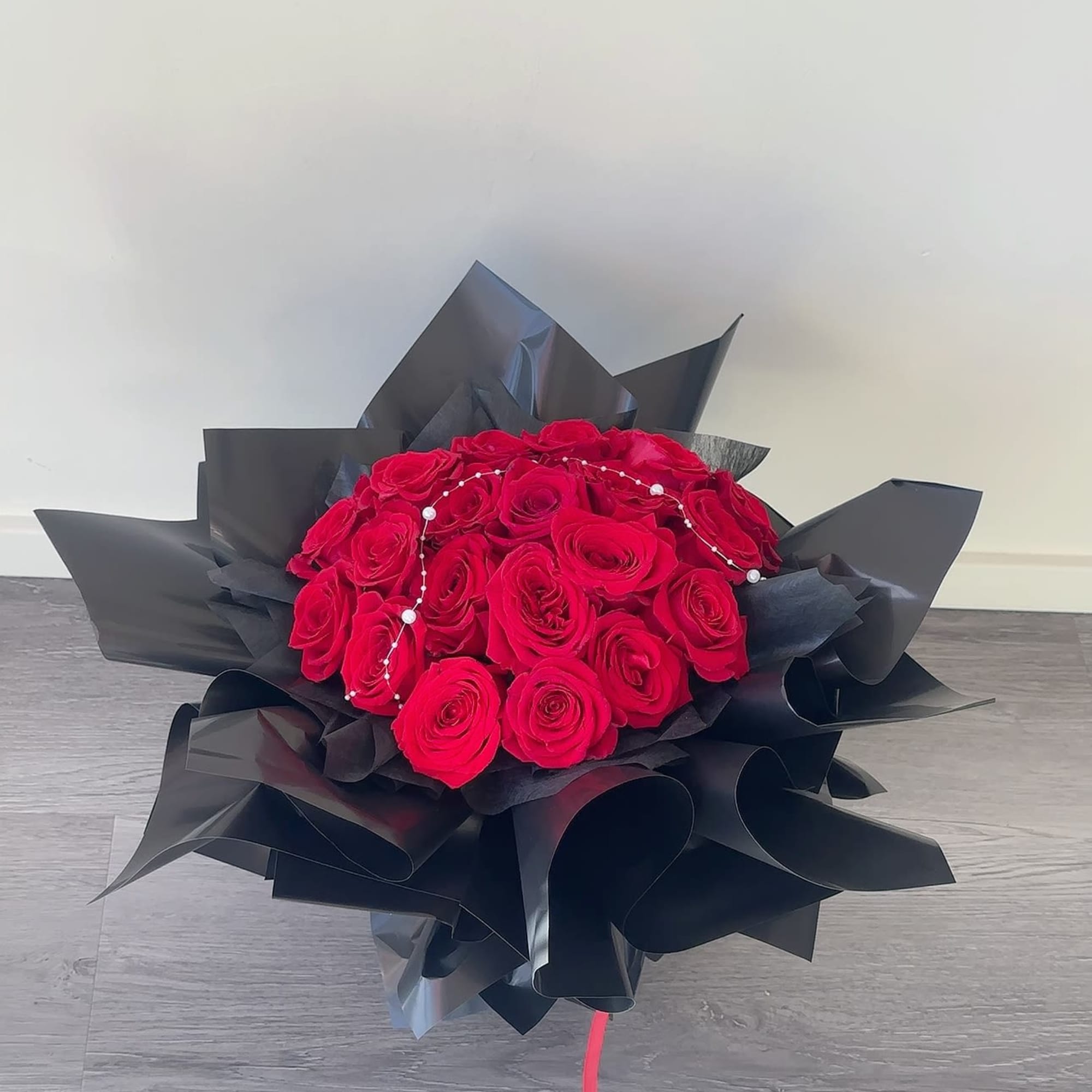 Bouquet of red roses wrapped in black paper