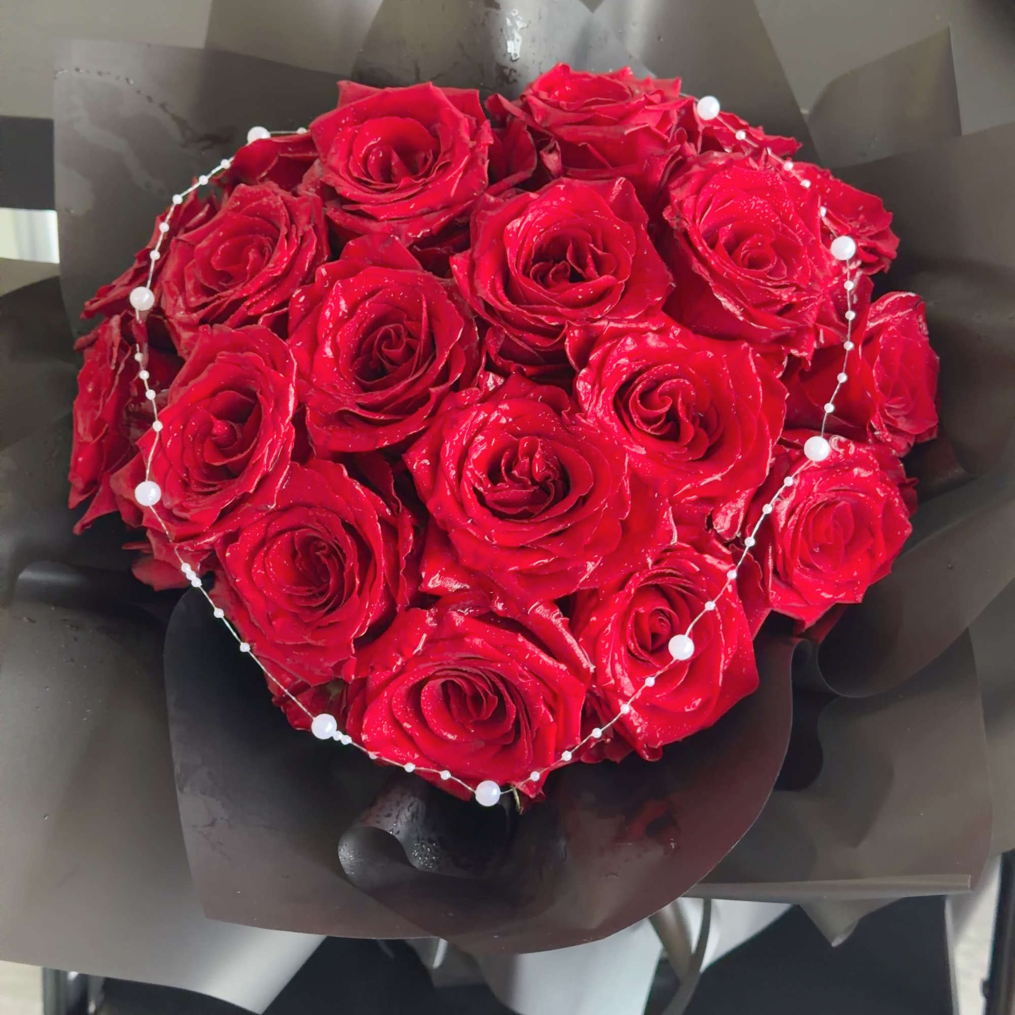 Heart-shaped bouquet of red roses with a pearl beaded accent