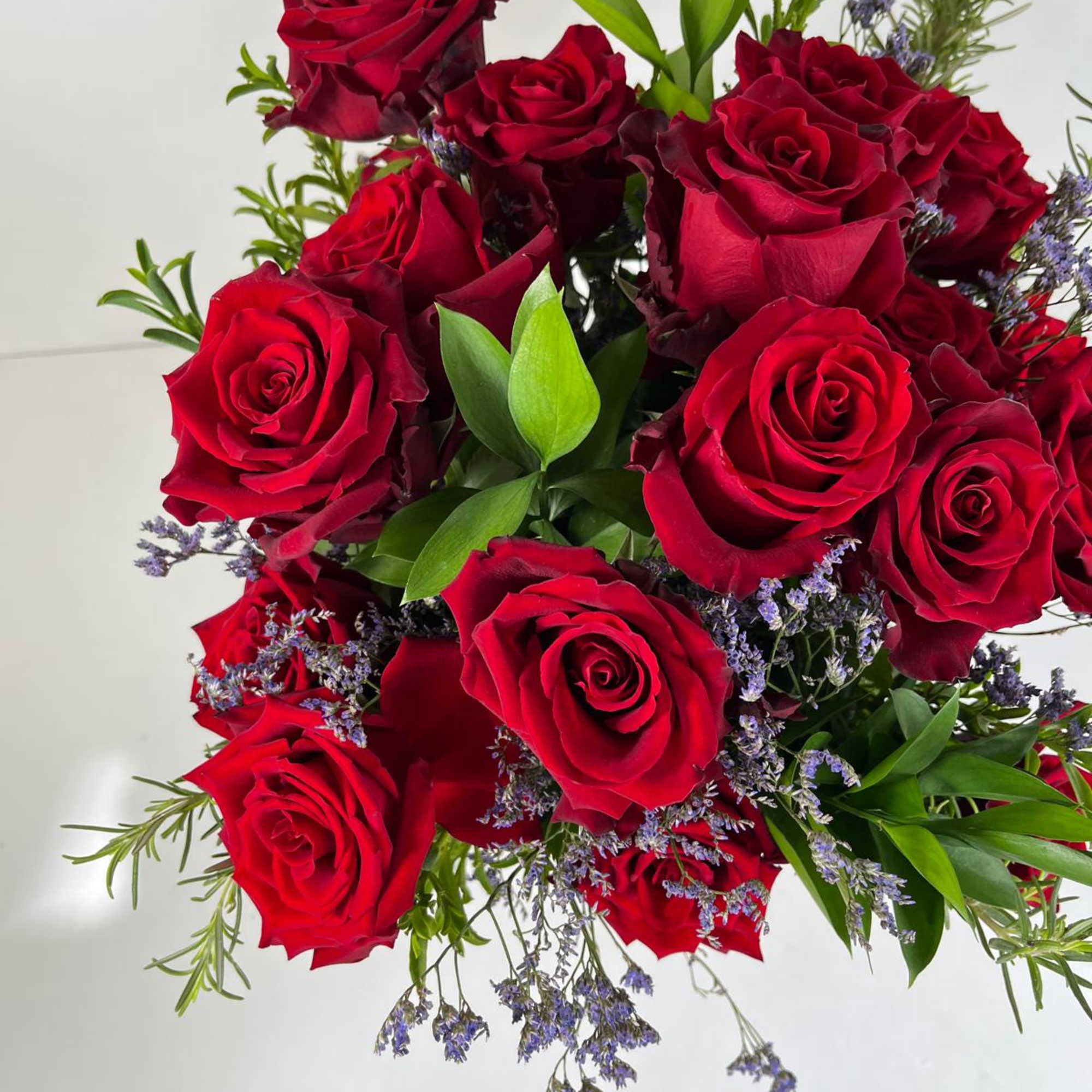 Bouquet of red roses with purple filler flowers and greenery