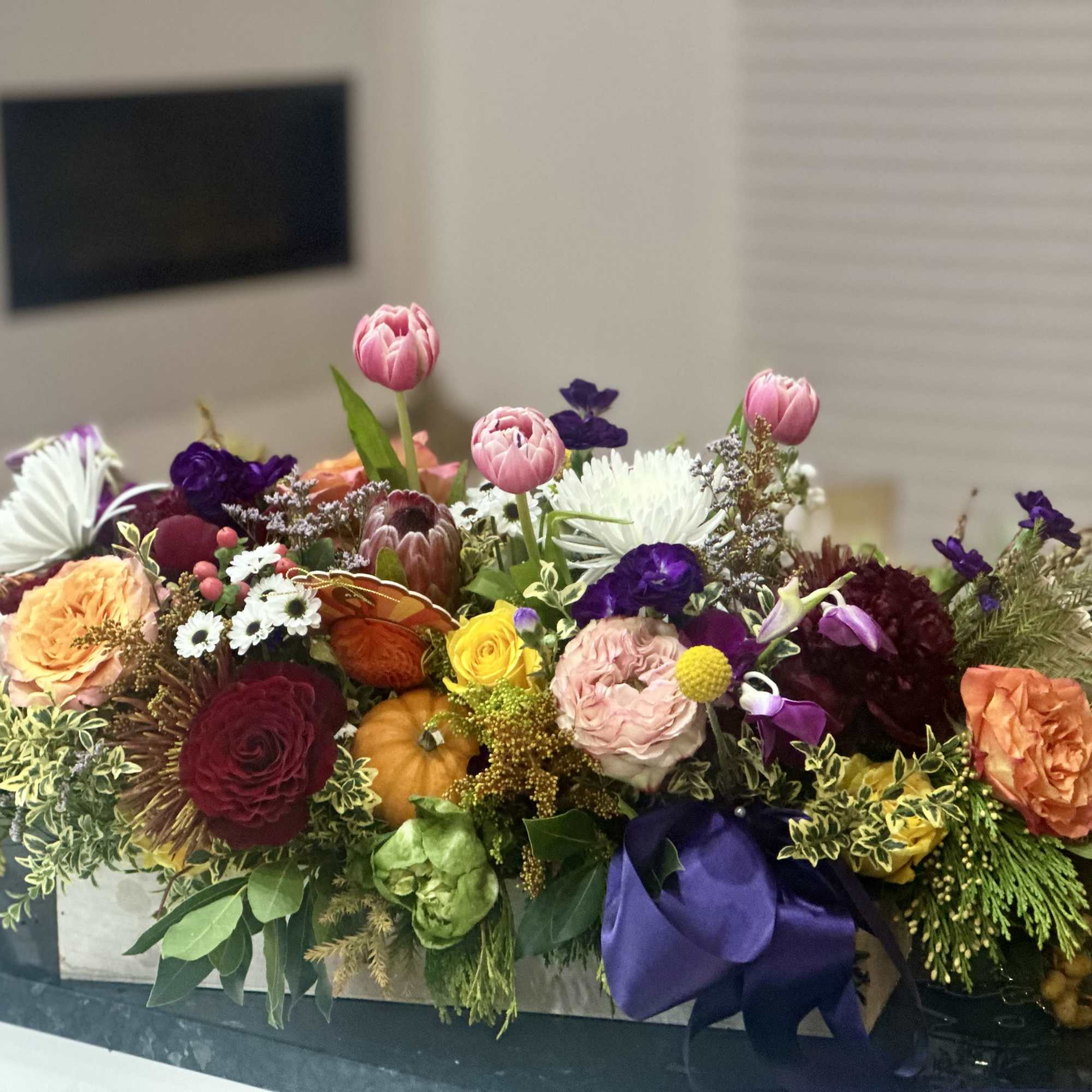 Mixed floral centerpiece with pink, purple, orange, and white blooms