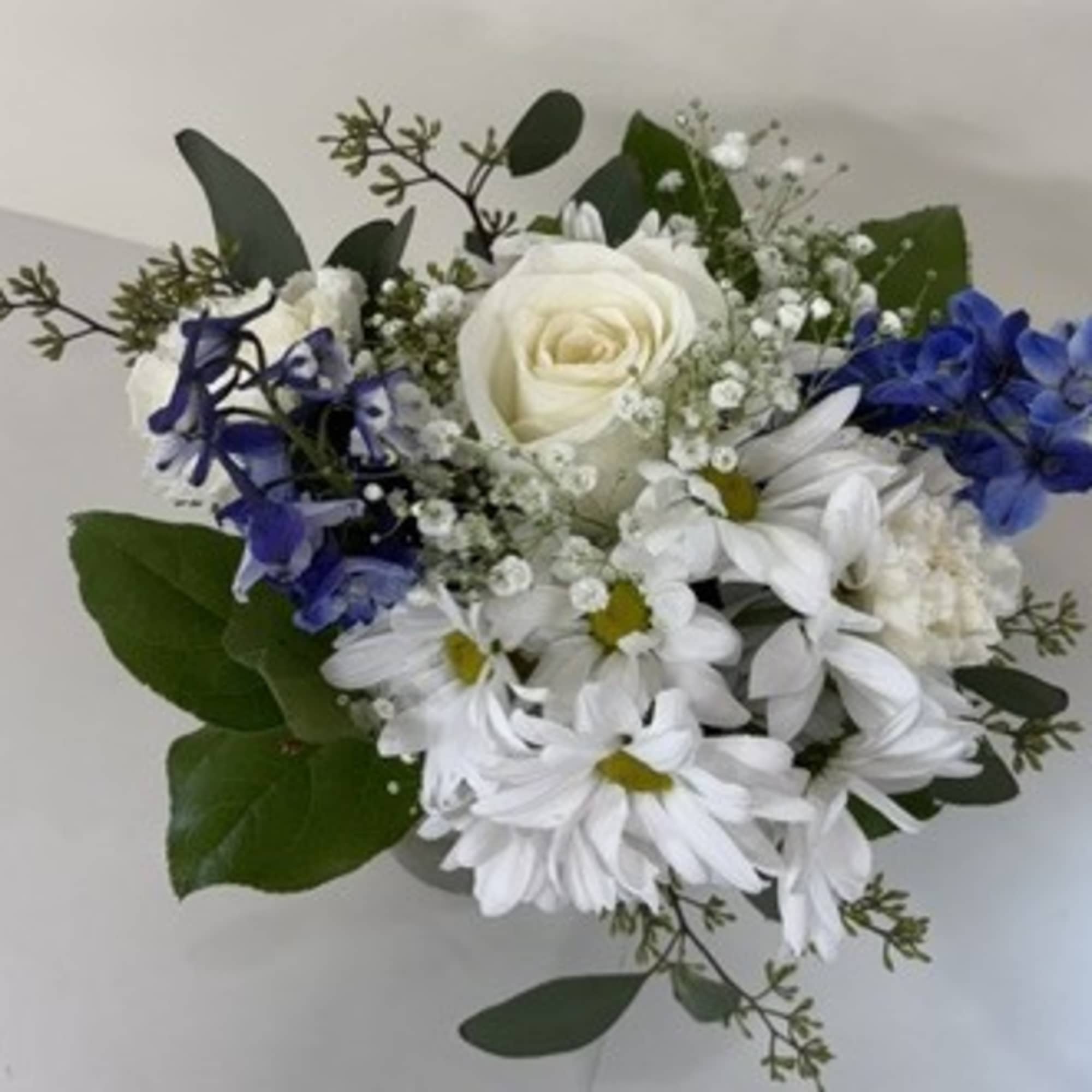 White rose and daisy bouquet with blue hydrangea accents