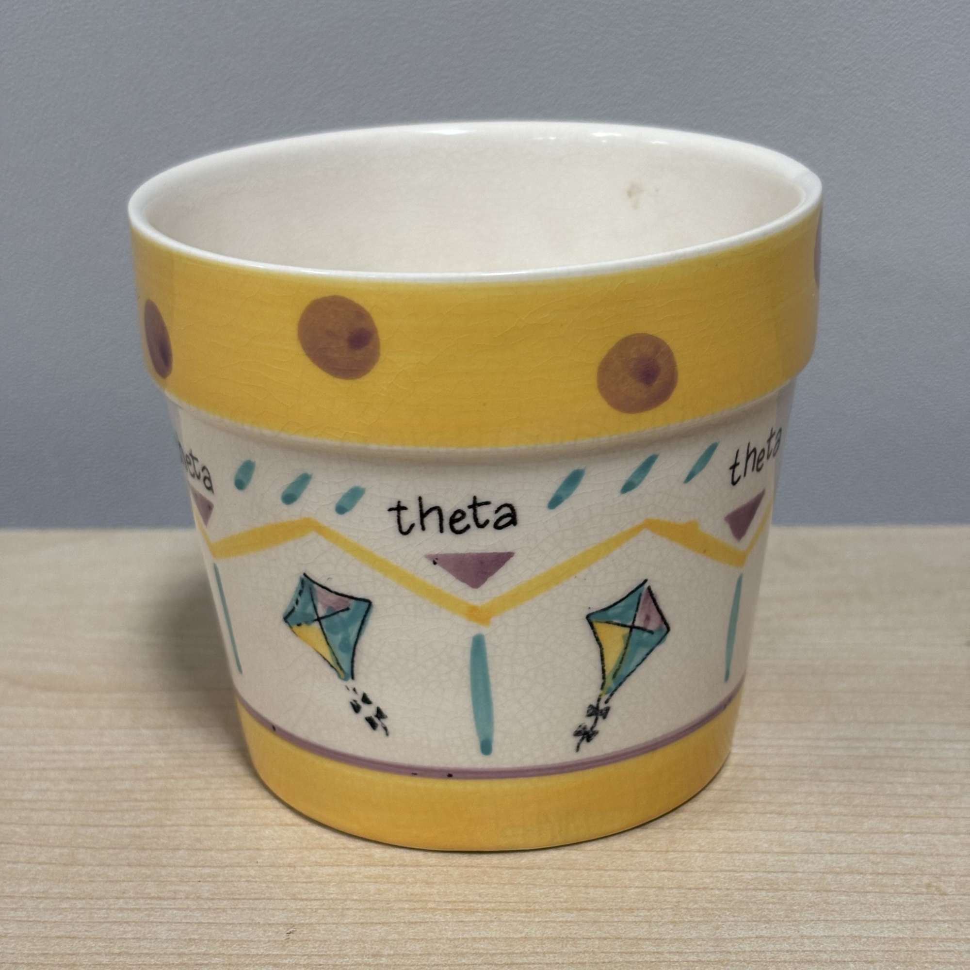 Decorative ceramic cup with yellow and multicolor geometric patterns