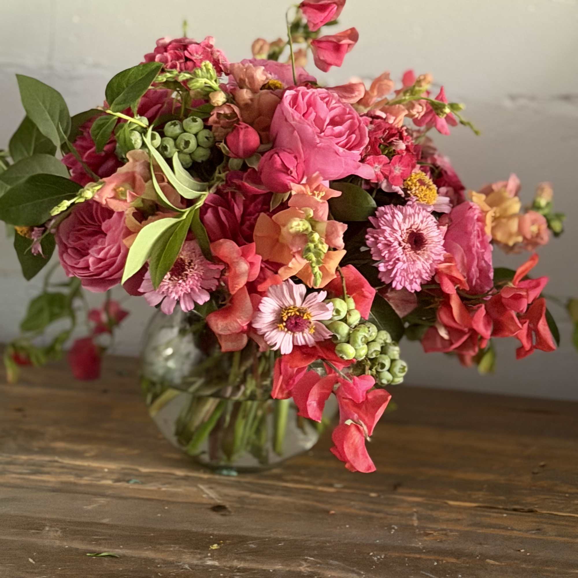 Pink and coral mixed bouquet in a clear glass vase