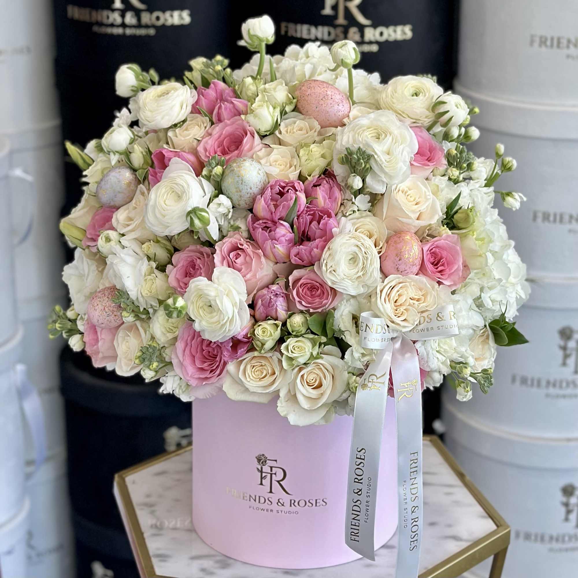 Pink and white rose bouquet in a round hat box with ribbon