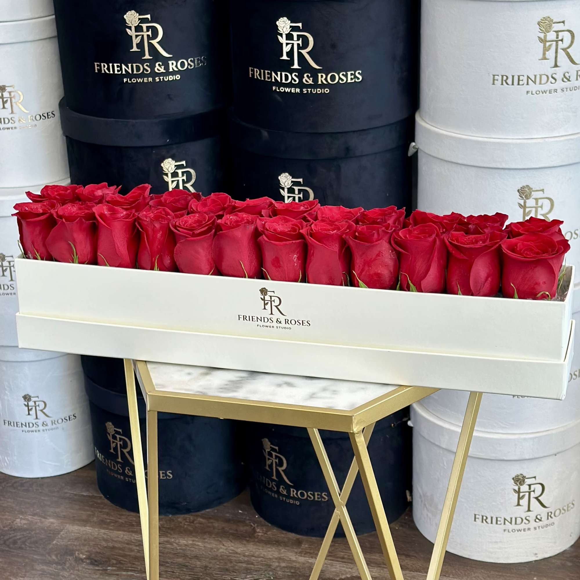 Long box of red roses on a gold stand