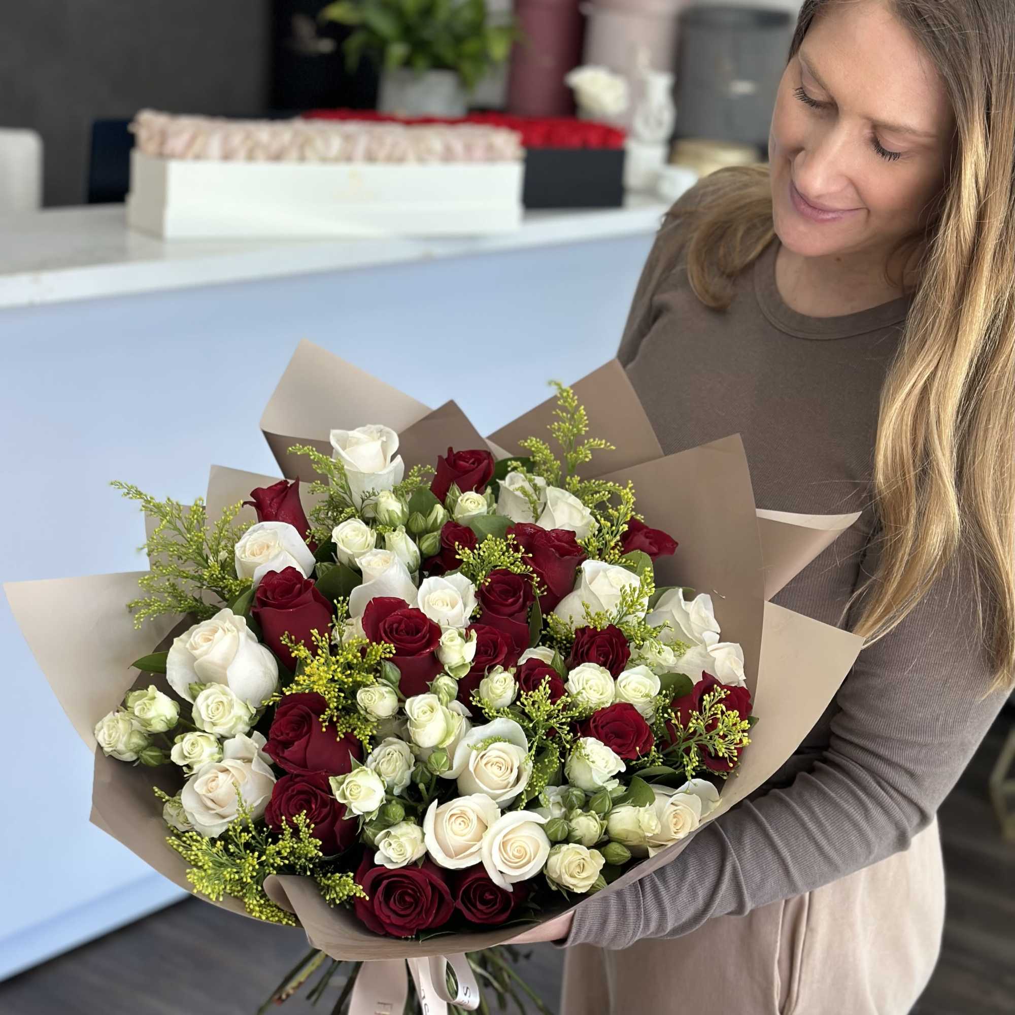 Woman holding a large bouquet of red and white roses
