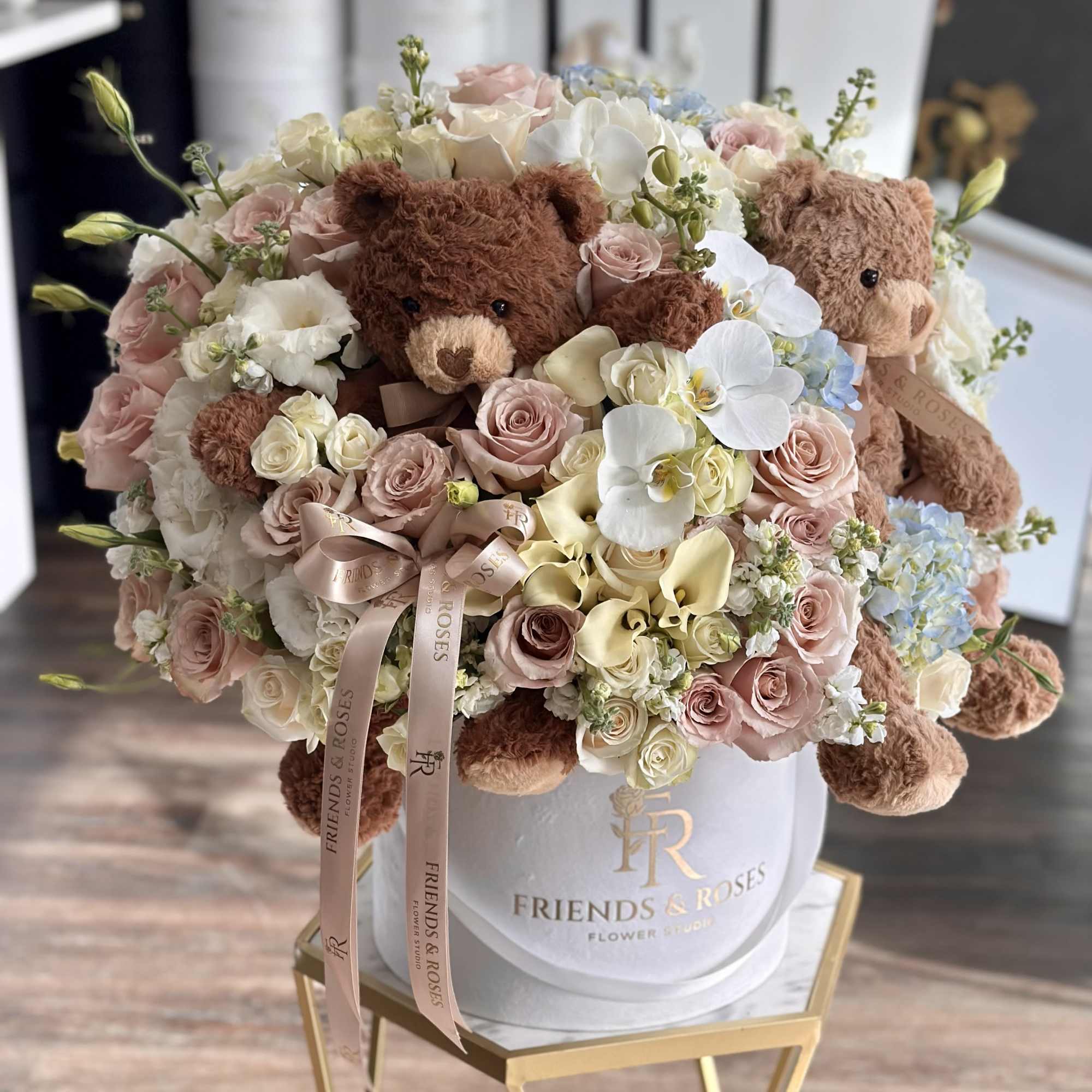 Bouquet of pastel roses and orchids with teddy bears in a white hat box