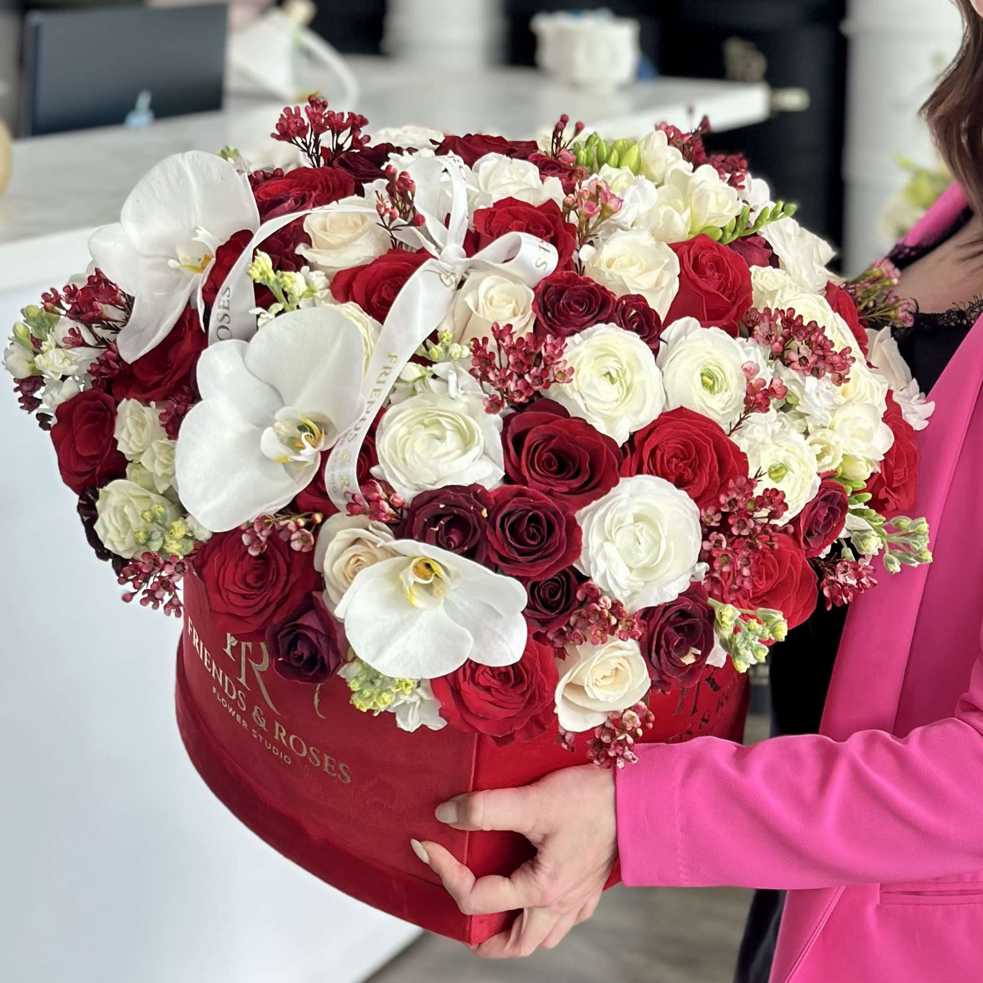 Heart-shaped box of red and white roses with white orchids