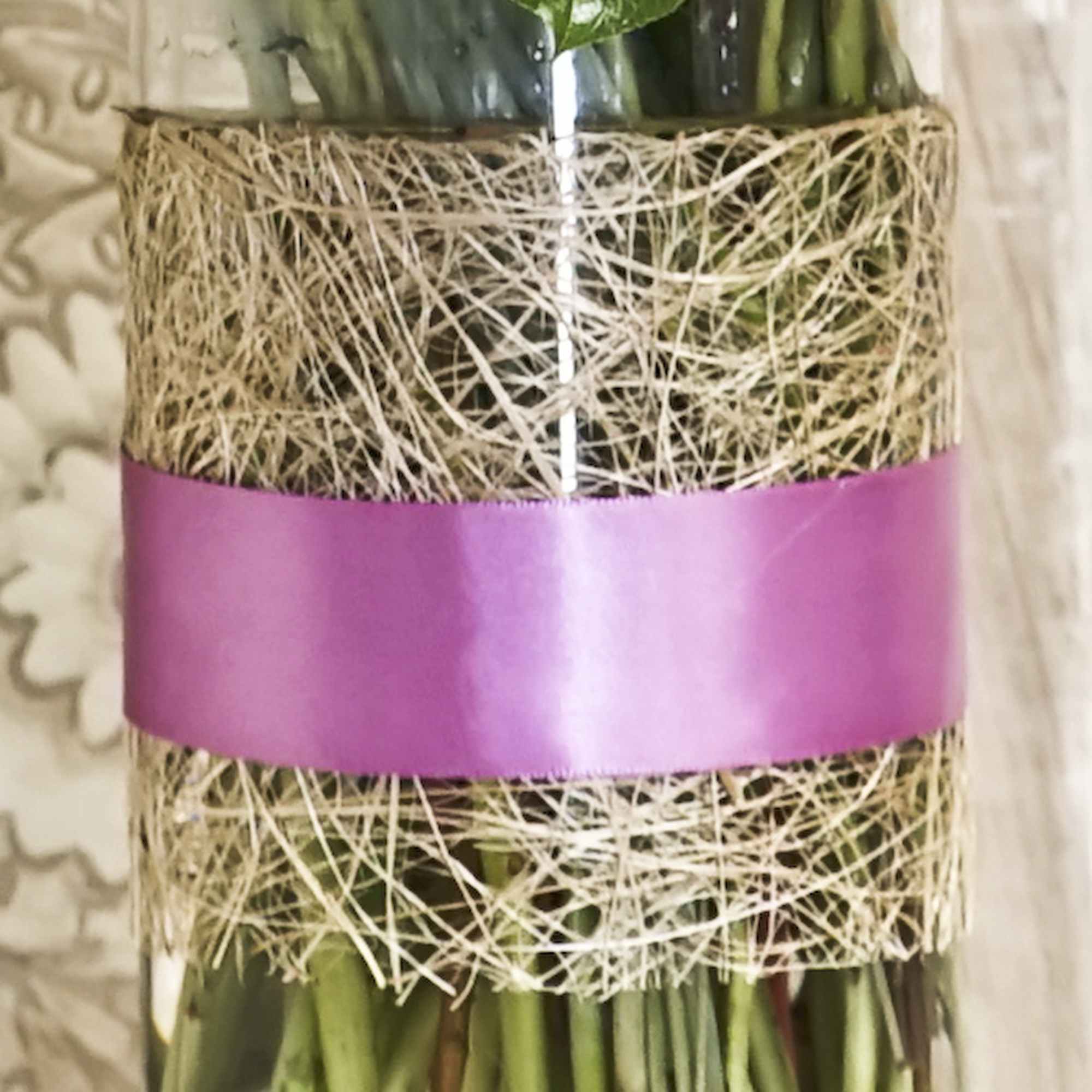 Wrapped bouquet stems tied with a pink satin band