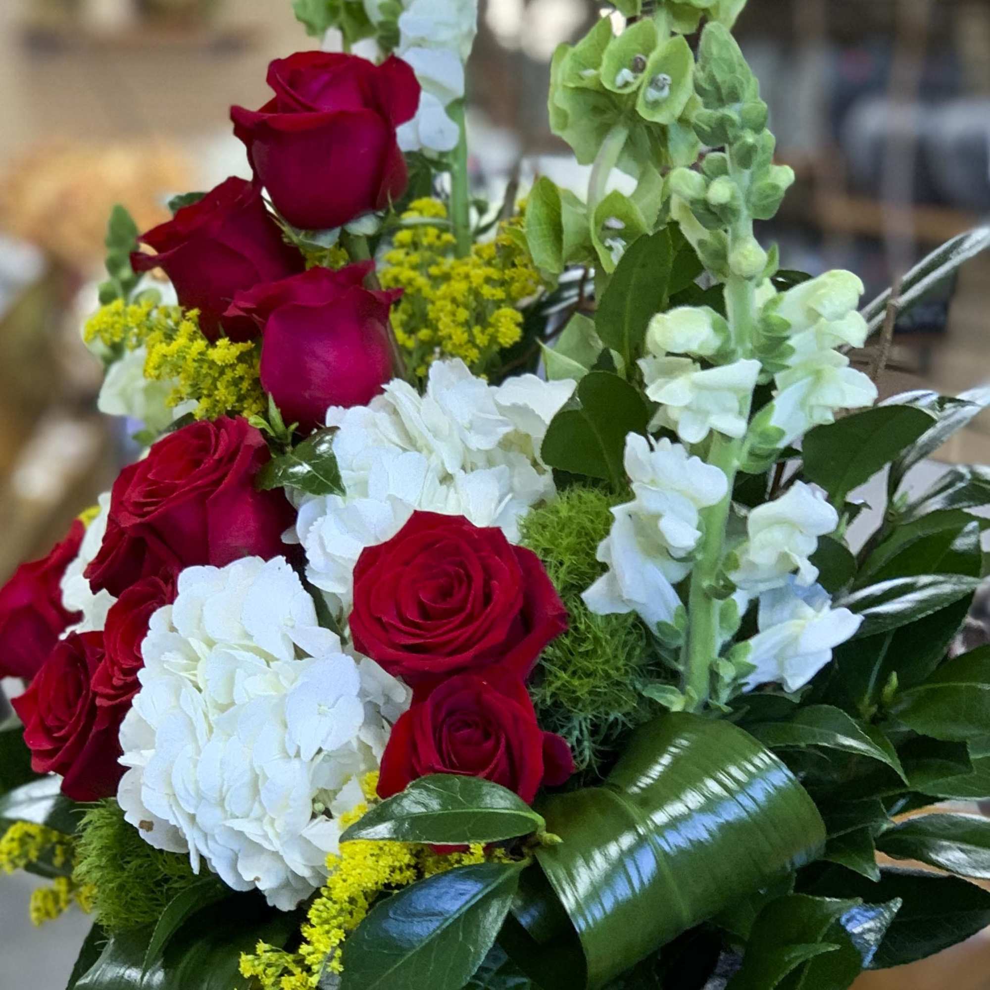 Bouquet of red roses, white hydrangeas, and pale green snapdragons