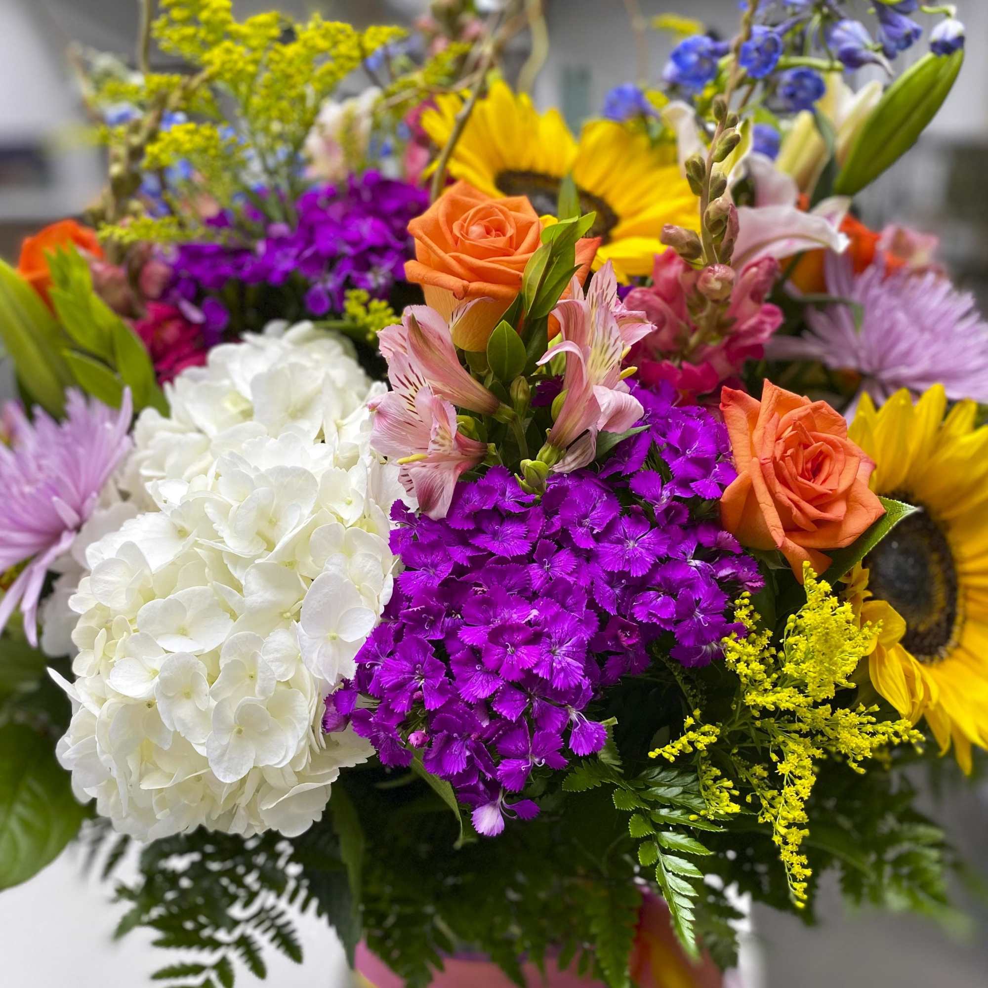 Colorful bouquet with roses, hydrangeas, sunflowers, and mixed blooms