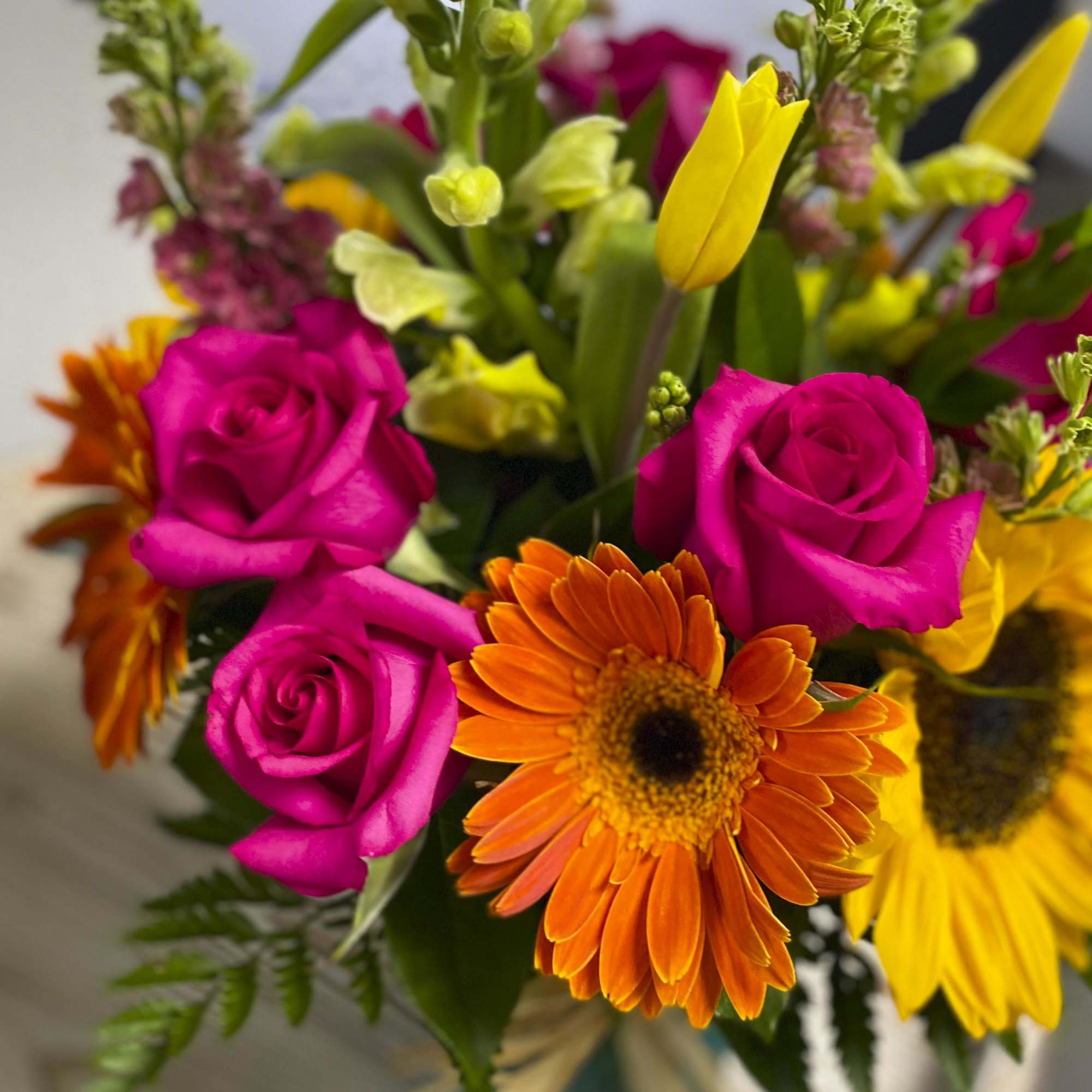 Bouquet of hot pink roses and orange gerbera daisies with yellow flowers