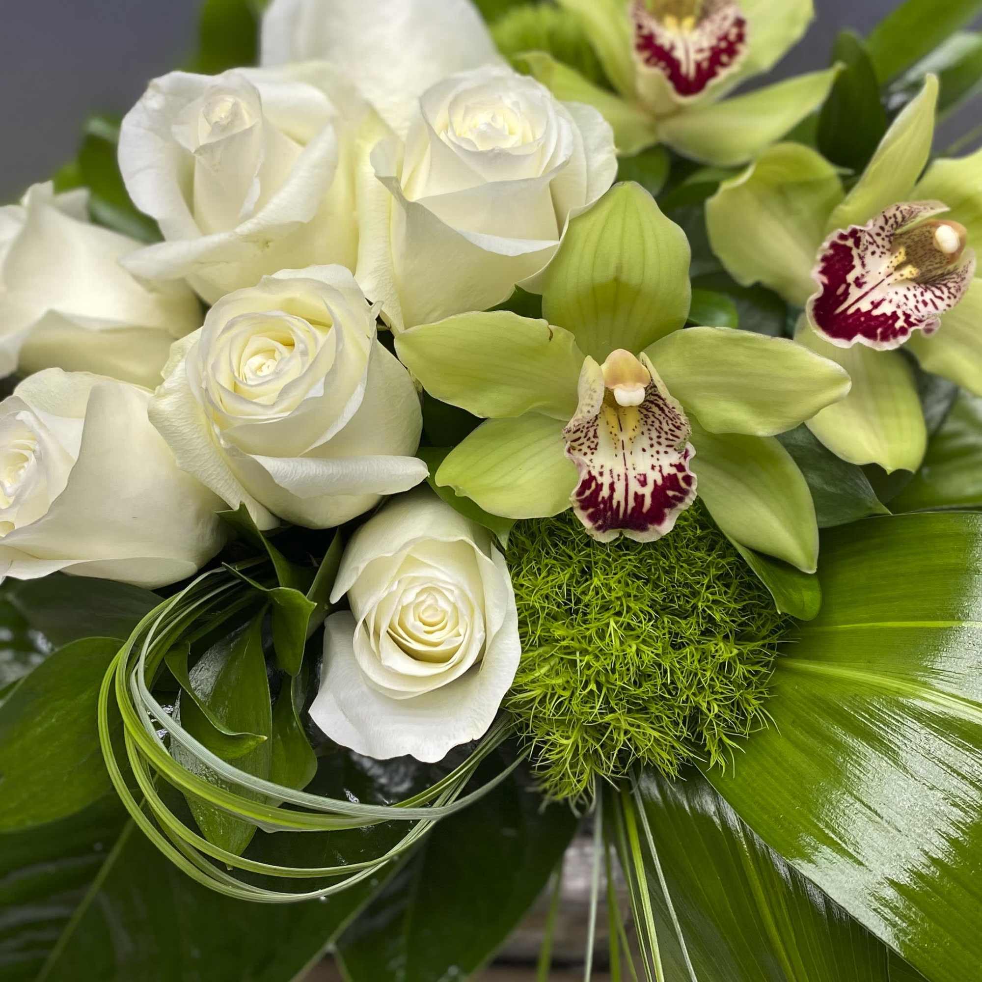 White roses and green orchids in a lush bouquet