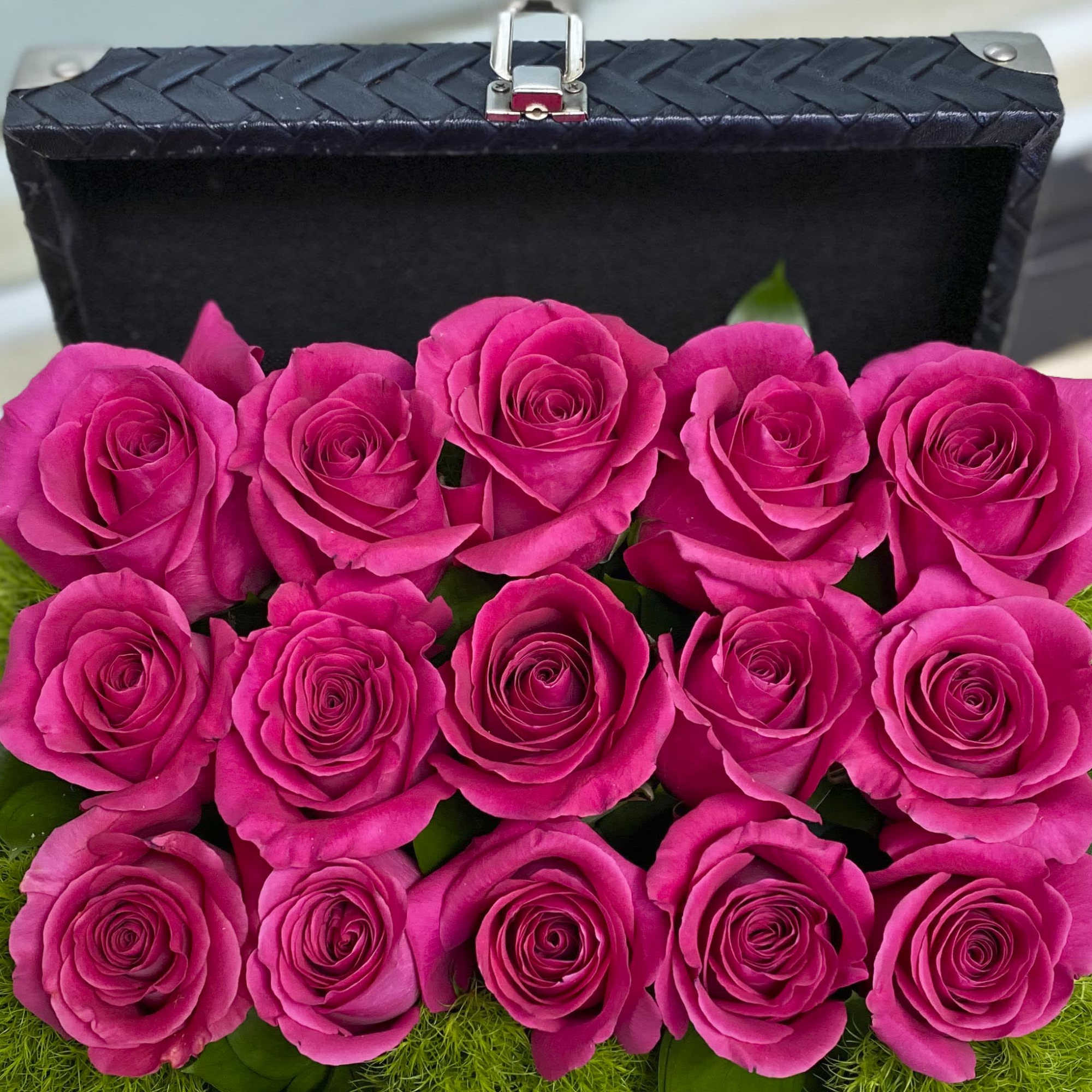 Box of bright pink roses arranged in rows