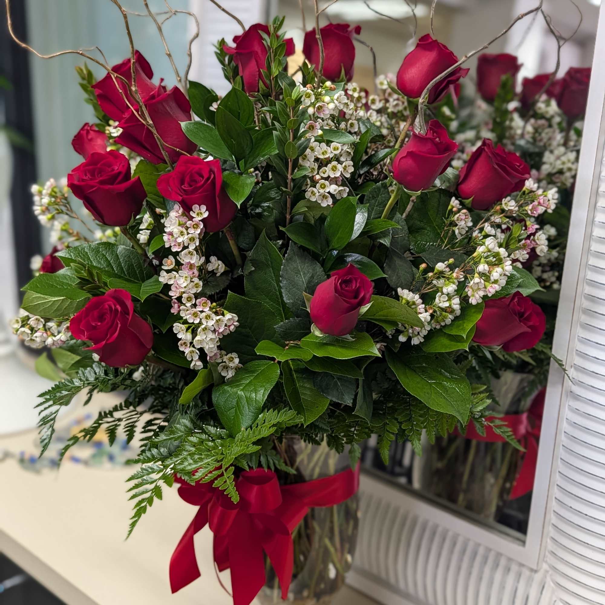 Bouquet of red roses and white filler flowers in a glass vase