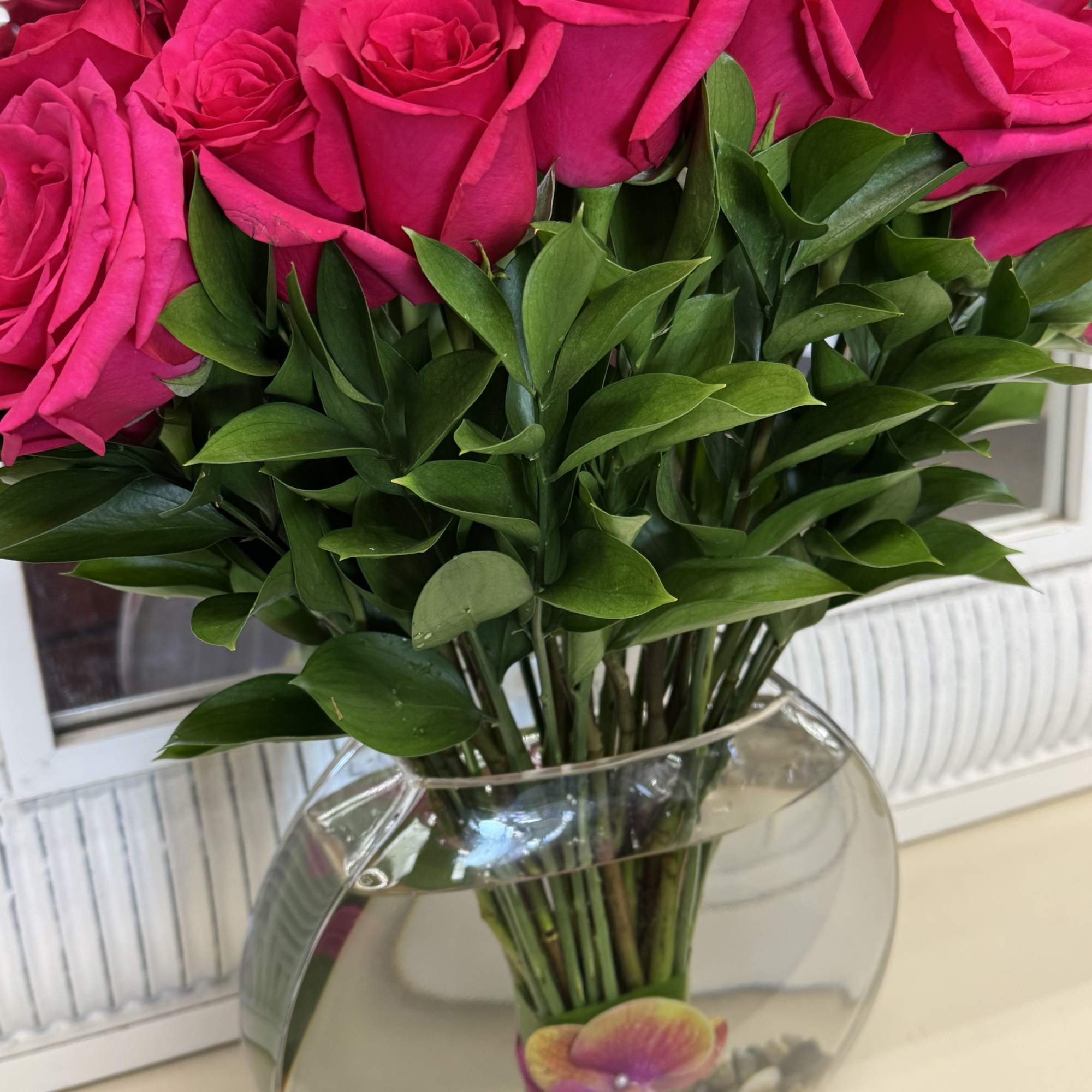 Bright pink roses arranged in a clear glass vase