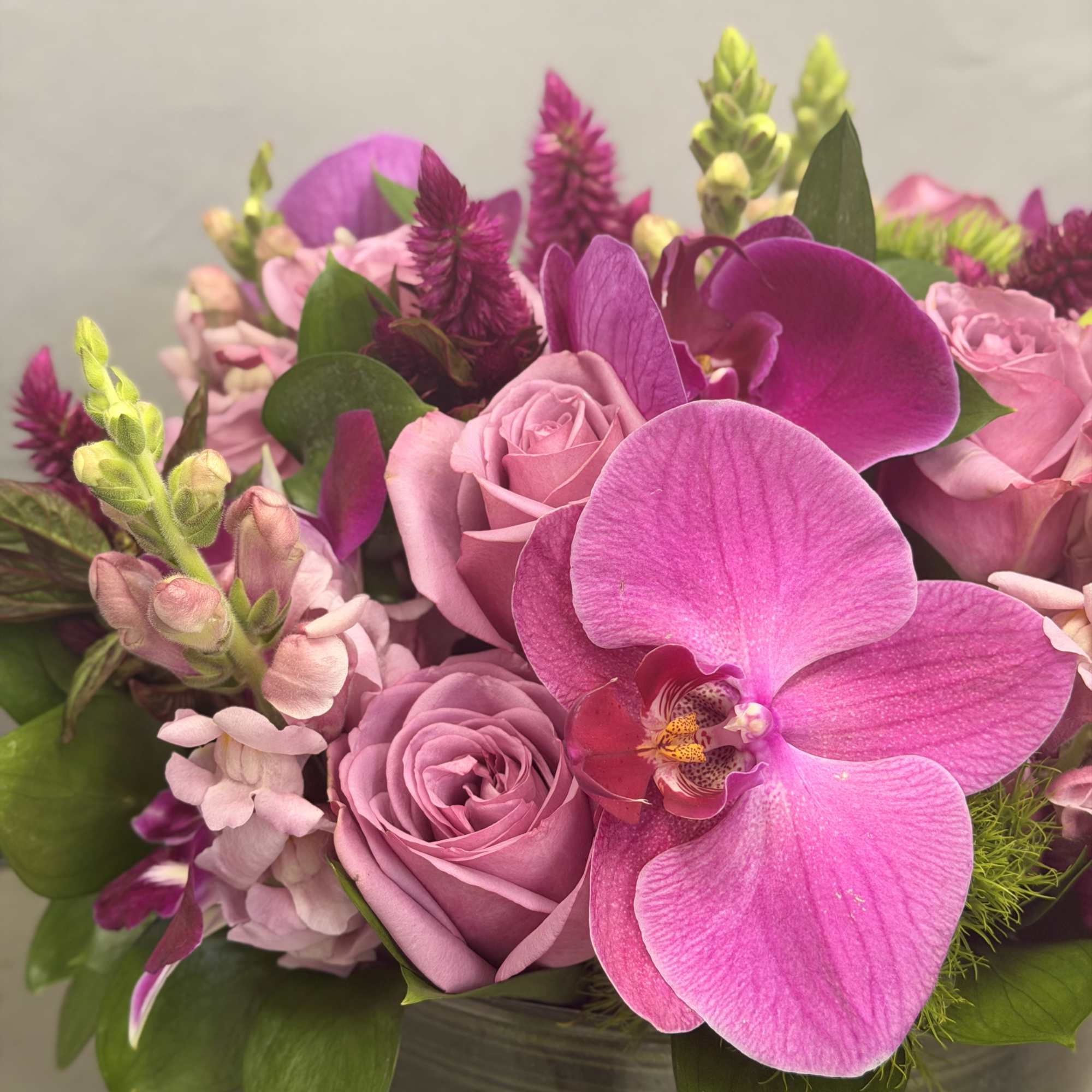 Pink roses and orchids arranged in a vase