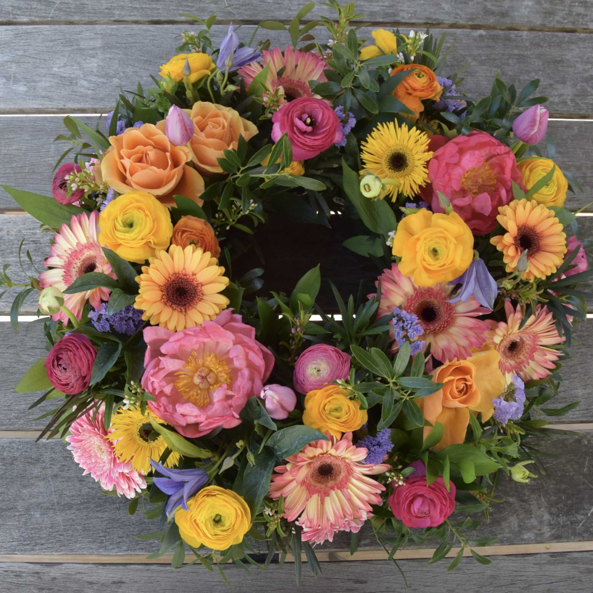 Colorful mixed flower wreath with roses, gerbera daisies, and ranunculus