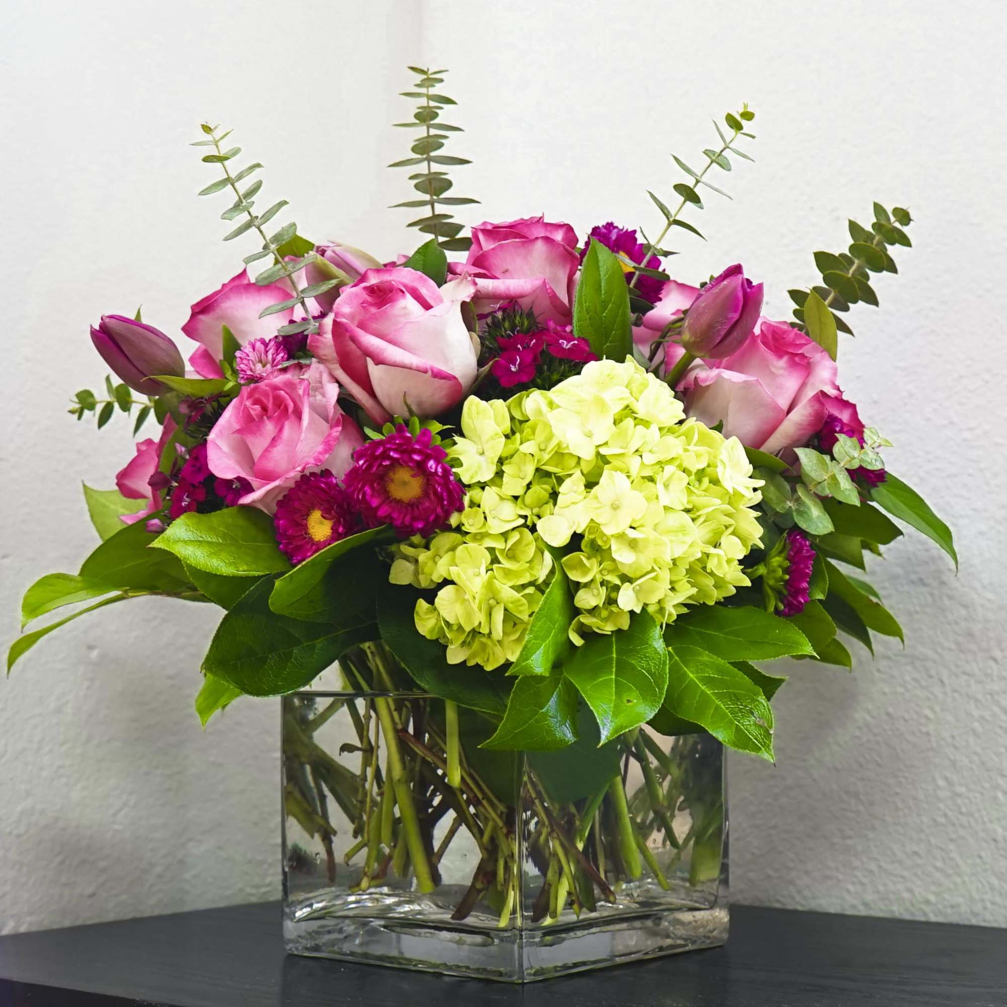 Pink roses and lime hydrangea in a clear square vase