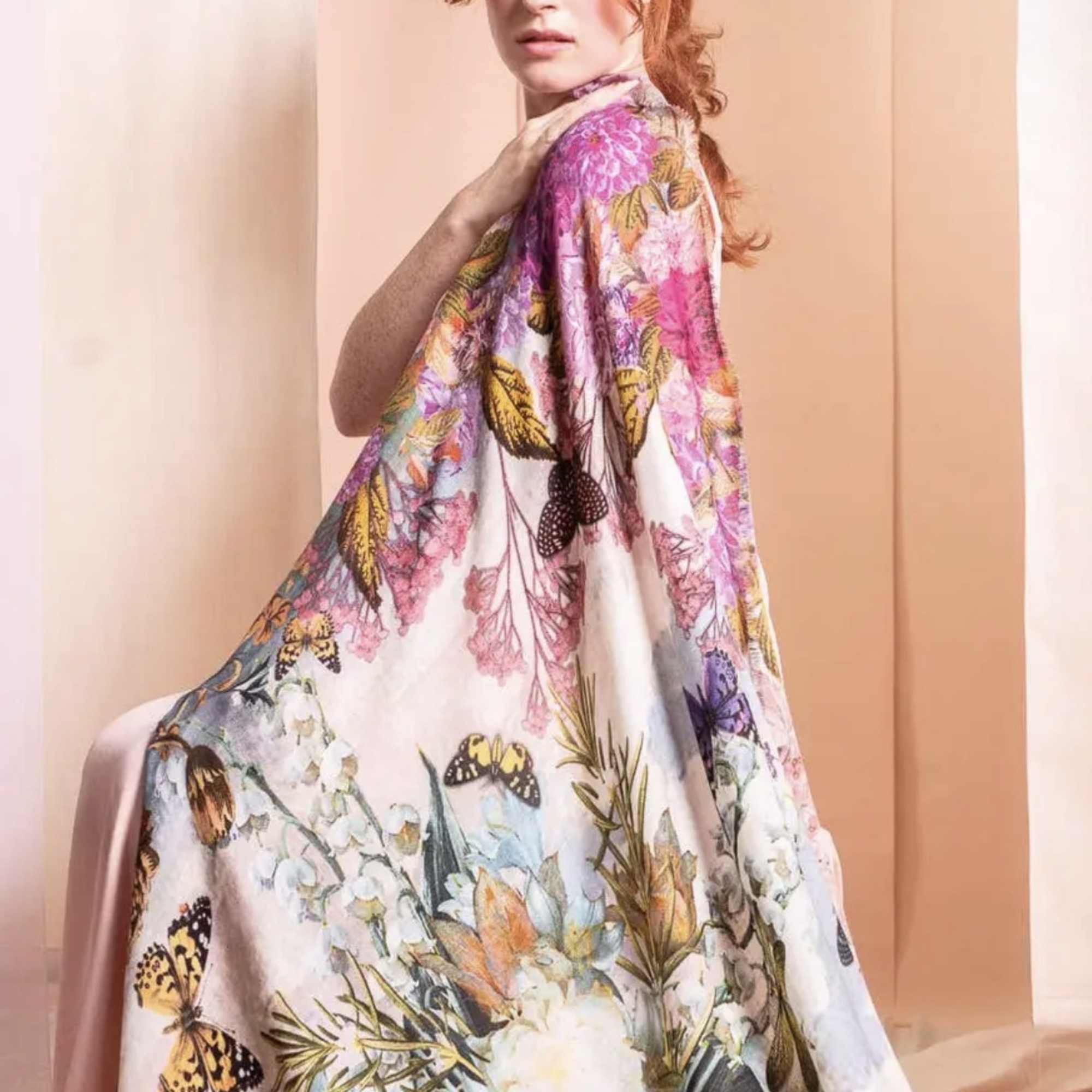 Woman wearing a floral-print cape with butterflies