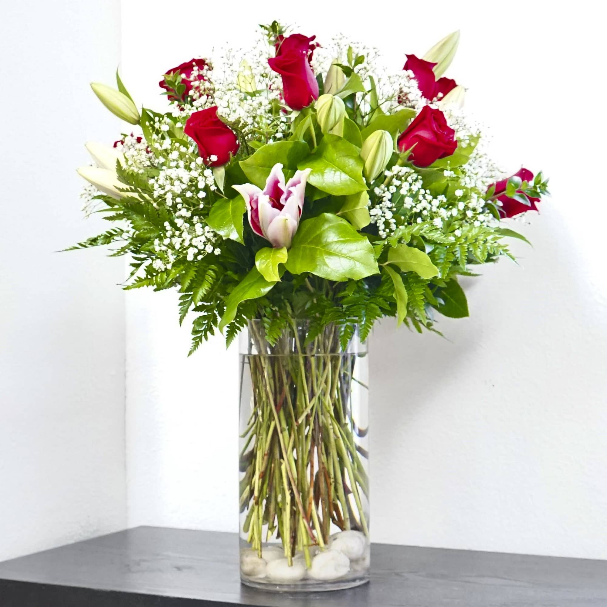 Red roses and white lilies in a clear glass vase, photo 3 of 3