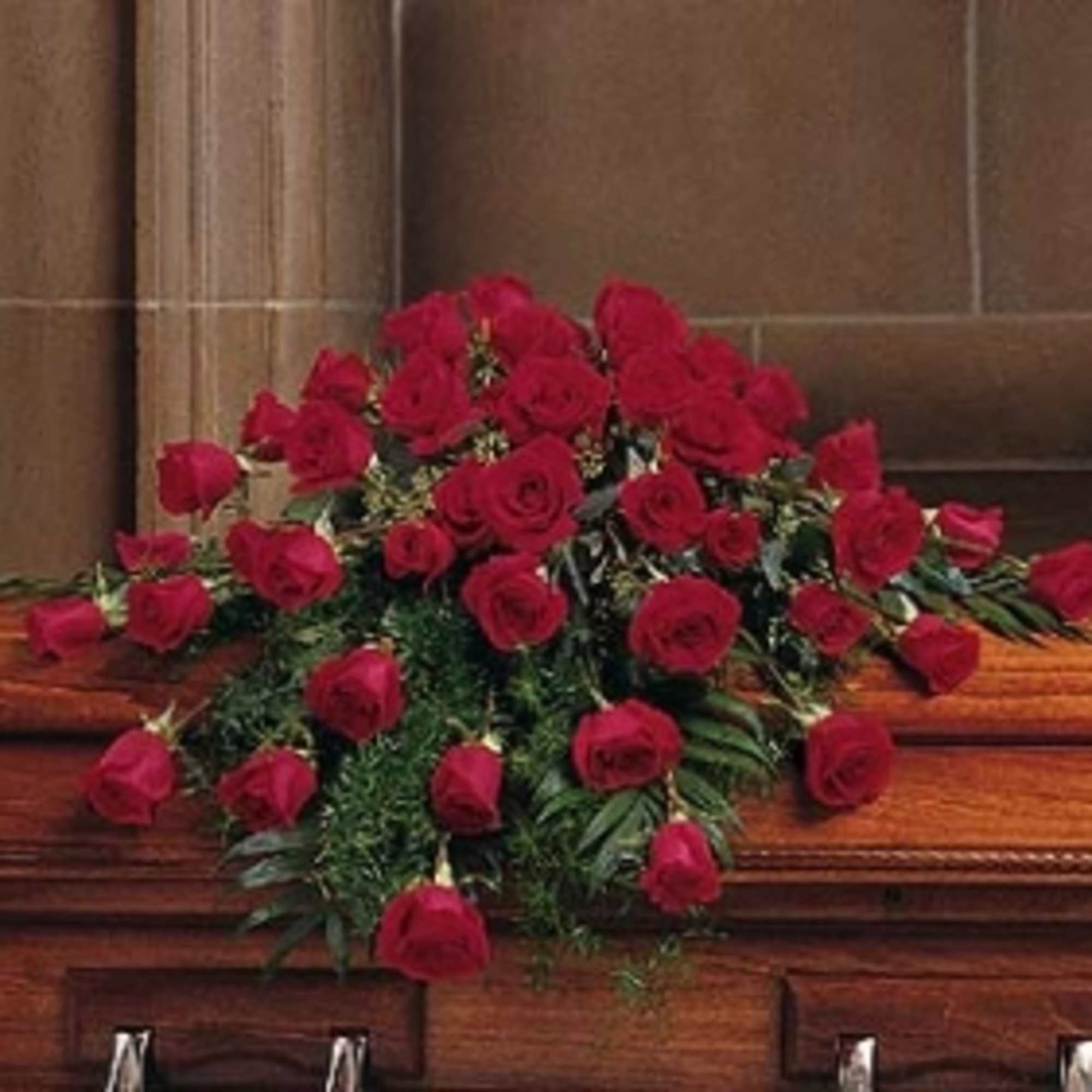 Red rose casket spray with greenery