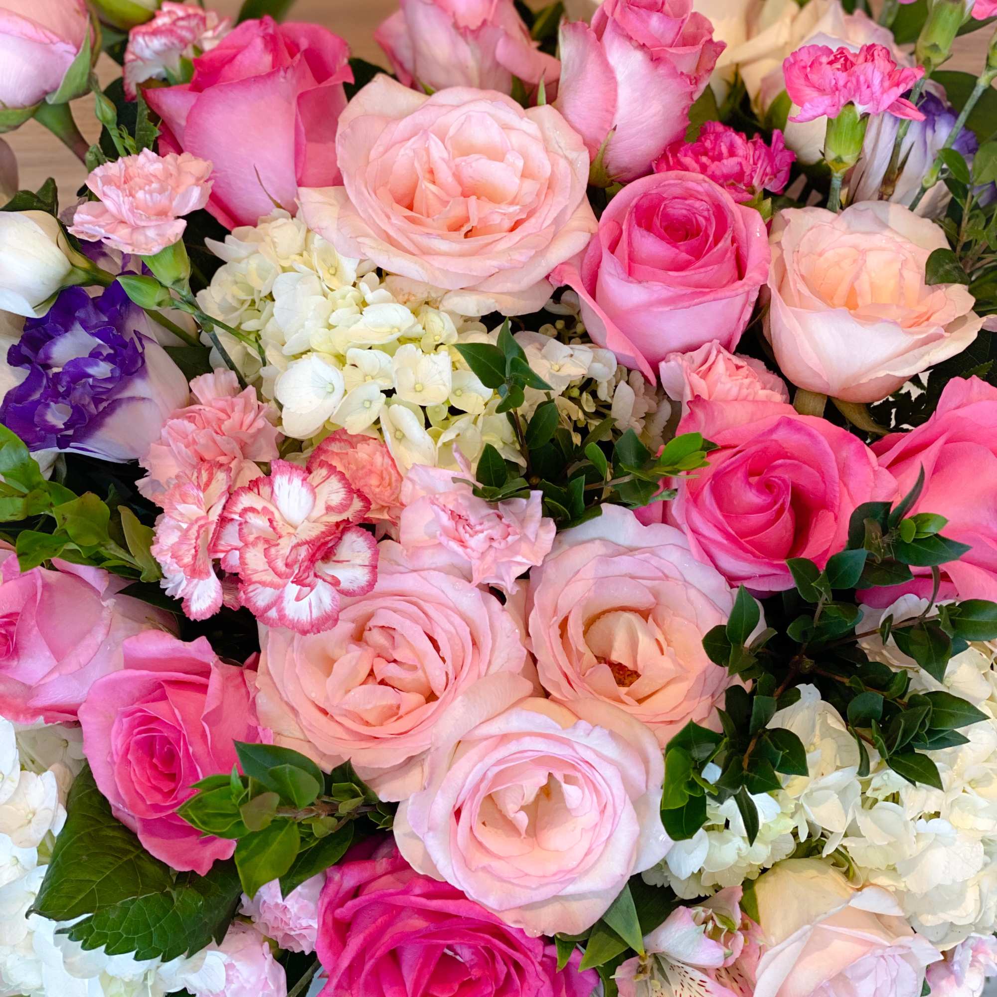 Bouquet of pink and peach roses with white hydrangea and carnations