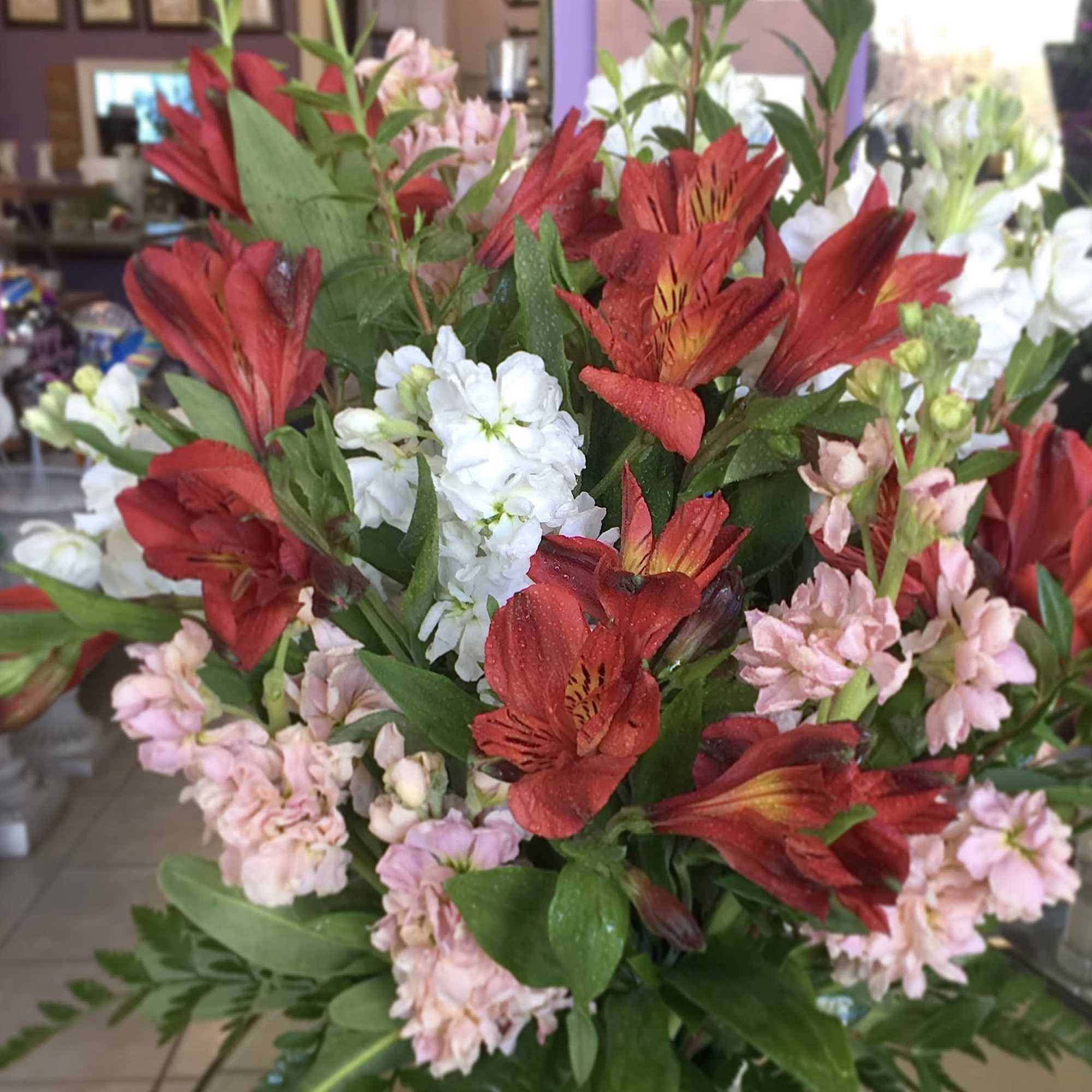 Bouquet of red, pink, and white flowers with green foliage