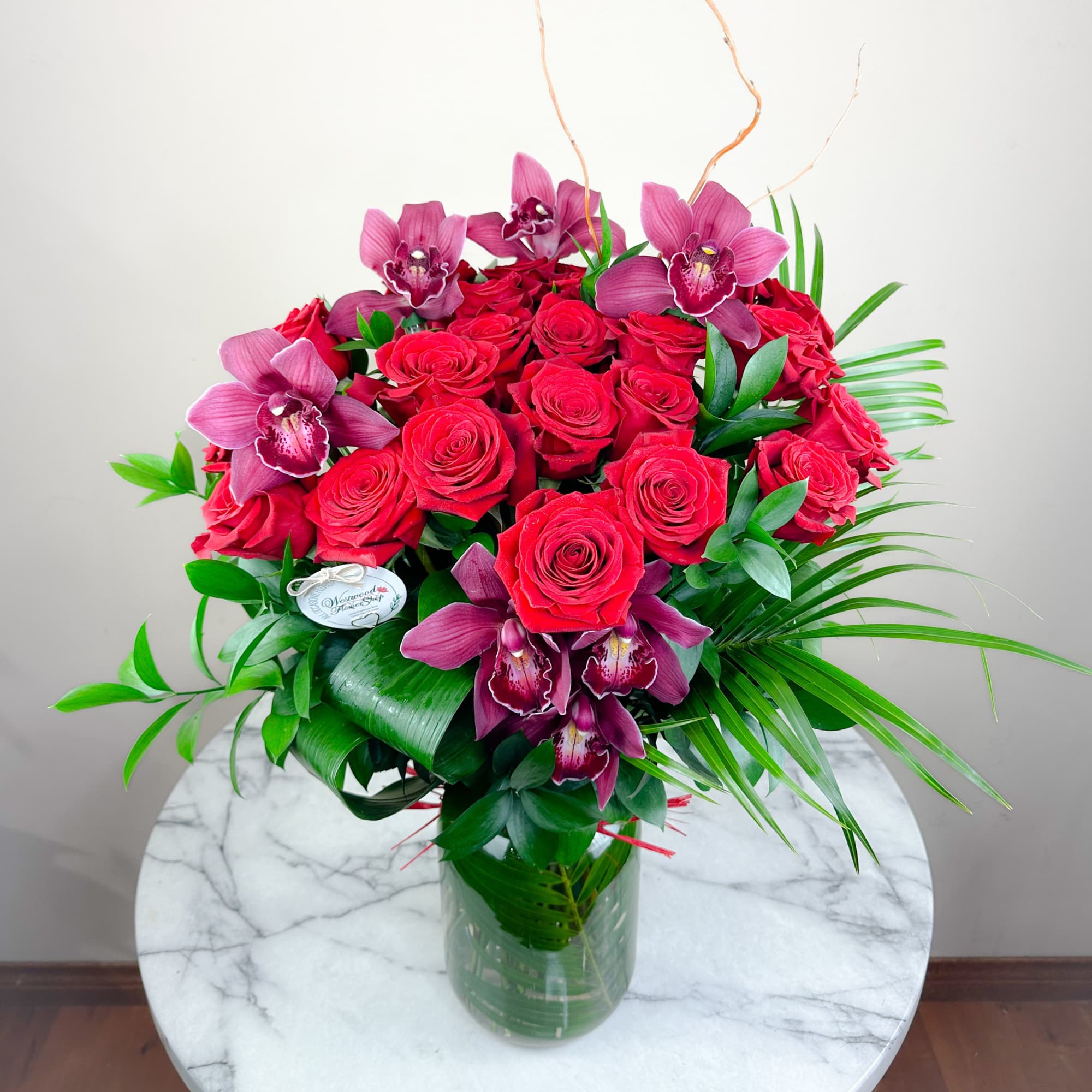 Bouquet of red roses and purple orchids in a glass vase, photo 3 of 3